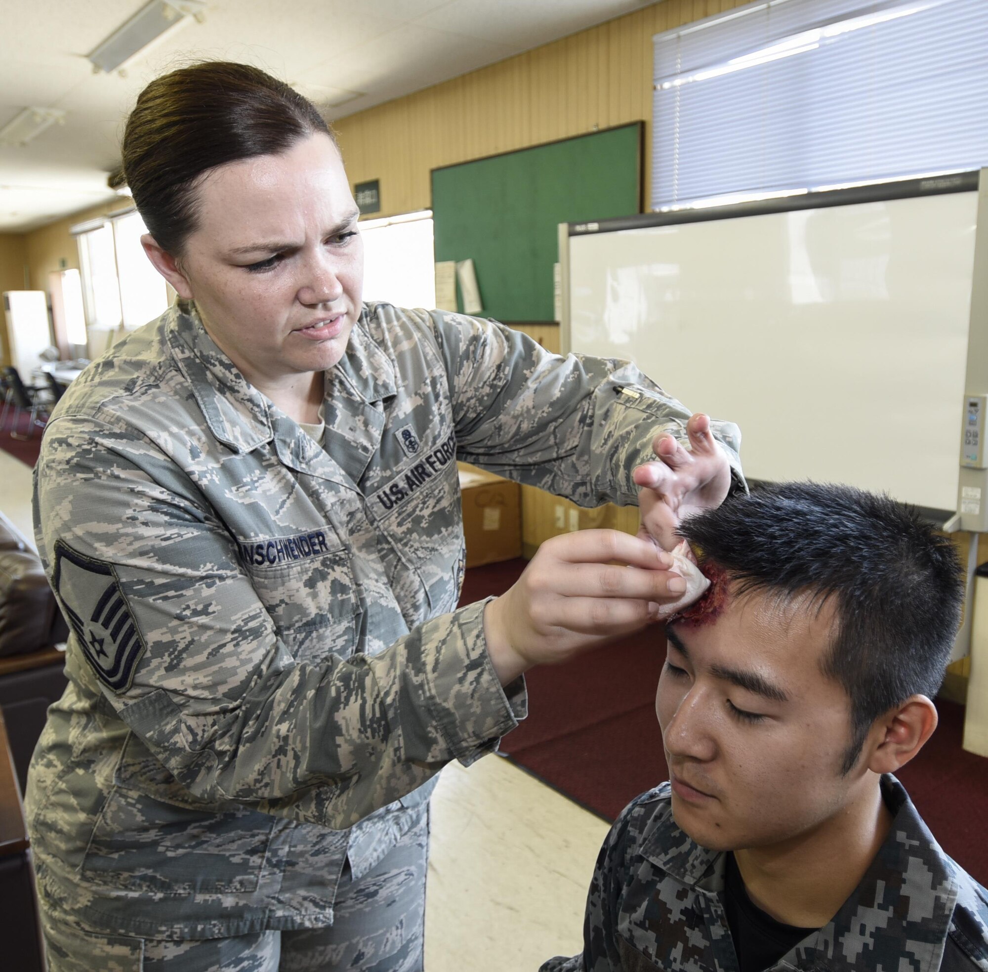 U.S. Air Force Master Sgt. Elizabeth Ehrnschwender, a wing self-assessment program manager with the 35th Fighter Wing staff agencies inspector general’s inspections office, left, applies moulage to Japan Air Self Defense Force Senior Airman Ken Tanaka prior to the start of a bilateral emergency management exercise at Misawa Air base, Japan, Aug. 31, 2016. Approximately 60 service members participated in the exercise to simulate injuries for medical staff to diagnose and respond to. (U.S. Air Force photo by Airman 1st Class Sadie Colbert)