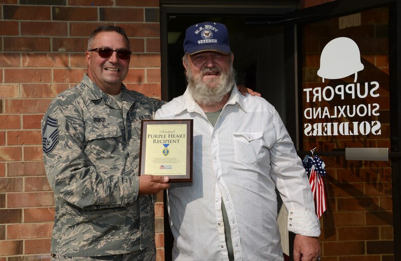 Purple Heart recipient, Roger Allen of Sioux City, Iowa is presented with a Purple Heart plaque by Iowa Air National Guard Chief Master Sgt. Barry Bower in Sioux City, Iowa on Augusts 31, 2016. The plaque was presented on behalf of Support Siouxland Soldiers in commemoration of Purple Heart day. Allen was injured in Vietnam while serving in the United States Marine Corps.