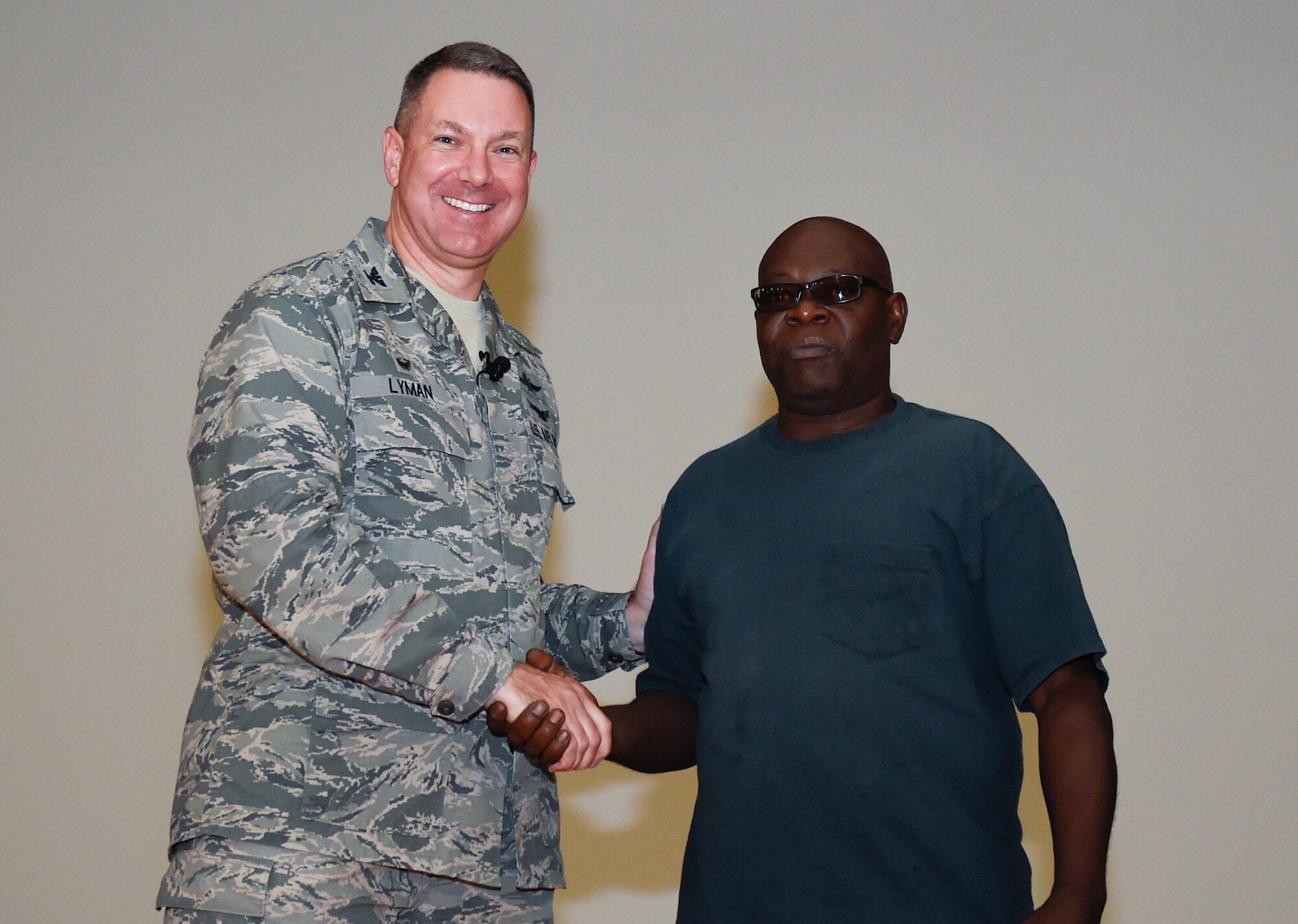 628th Airbase Wing commander Col. Robert Lyman congratulates Joseph Mack, 628th Civil Engineer Squadron for his 40-year service award during a commander’s call at Joint Base Charleston, South Carolina, Aug. 19, 2016. (U.S. Air Force photo by Staff Sgt. Andrea Salazar/Released)