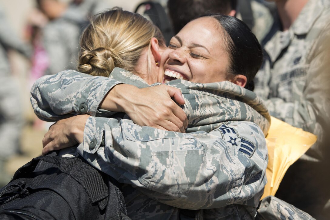 Airmen embrace at Minot Air Force Base, N.D., Aug. 29, 2016, after returning from a deployment. Airmen assigned to the 5th Bomb Wing deployed to Andersen Air Force Base in Guam to help provide continuous bomber presence. Air Force photo by Airman 1st Class J.T. Armstrong