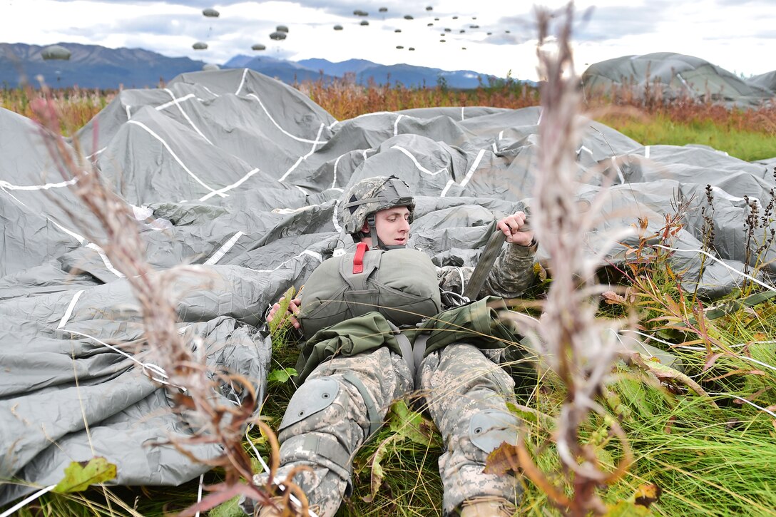Army Pfc. Oliver Larson pulls on a harness strap after landing during a joint forcible entry exercise onto Malemute drop zone during Exercise Spartan Agoge at Joint Base Elmendorf-Richardson, Alaska, Aug. 23, 2016. Larson is a paratrooper assigned to the 25th Infantry Division’s Company H, 1st Battalion, 501st Parachute Infantry Regiment, 4th Brigade Combat Team, Alaska. Air Force photo by Justin Connaher