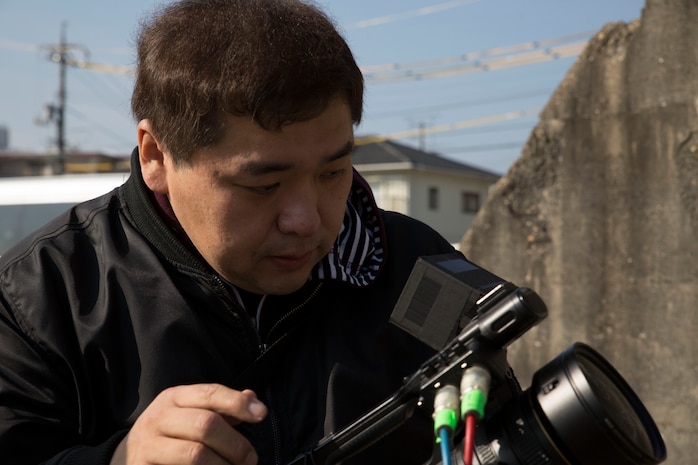 Yamaguchi Yuki, a videographer for Hakuhodo Inc., checks the settings on his camera at Marine Corps Air Station Iwakuni, Japan, Nov. 29, 2016. Yuki took video of the hangar to show the damage it sustained after a bombing in World War II. (U.S. Marine Corps photo by Pfc. Gabriela Garcia-Herrera)