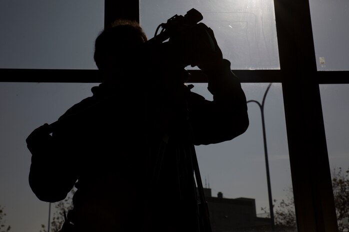 Yamaguchi Yuki, a videographer for Hakuhodo Inc., films Japan Maritime Self-Defense Force broadcasters at Marine Corps Air Station Iwakuni, Japan, Nov. 29, 2016. The broadcasters stood on a platform that wraps around the Type Zero Carrier Fighter. This helped set the scene for the video. (U.S. Marine Corps photo by Pfc. Gabriela Garcia-Herrera)