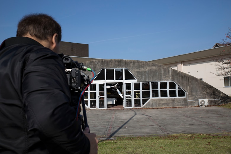 Yamaguchi Yuki, a videographer for Hakuhodo Inc., collects video for a promotion video for the Japan Maritime Self-Defense Force at Marine Corps Air Station Iwakuni, Japan, Nov. 29, 2016. The JMSDF public affairs team escorted the Hakuhodo film crew around base to collect footage for the video. The Zero Hangar was a place the crew wanted to film because of how unique it is to MCAS Iwakuni. (U.S. Marine Corps photo by Pfc. Gabriela Garcia-Herrera)