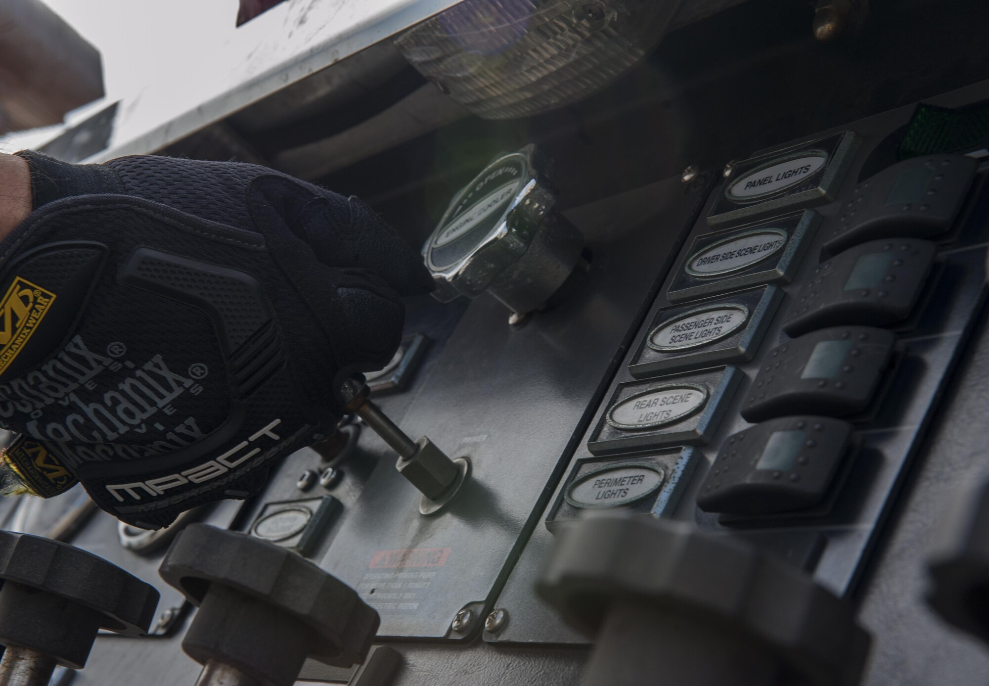 U.S. Air Force Airman Javier Gomez, 18th Civil Engineer Squadron firefighter, prepares a primer on a Pierce Enforcer Nov. 30, 2016, at Kadena Air Base, Japan. The primer ensures optimum performance of the Enforcer by getting air out of the pumps so water can go in faster. (U.S. Air Force photo by Senior Airman Lynette M. Rolen/Released)