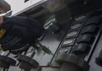 U.S. Air Force Airman Javier Gomez, 18th Civil Engineer Squadron firefighter, prepares a primer on a Pierce Enforcer Nov. 30, 2016, at Kadena Air Base, Japan. The primer ensures optimum performance of the Enforcer by getting air out of the pumps so water can go in faster. (U.S. Air Force photo by Senior Airman Lynette M. Rolen/Released)