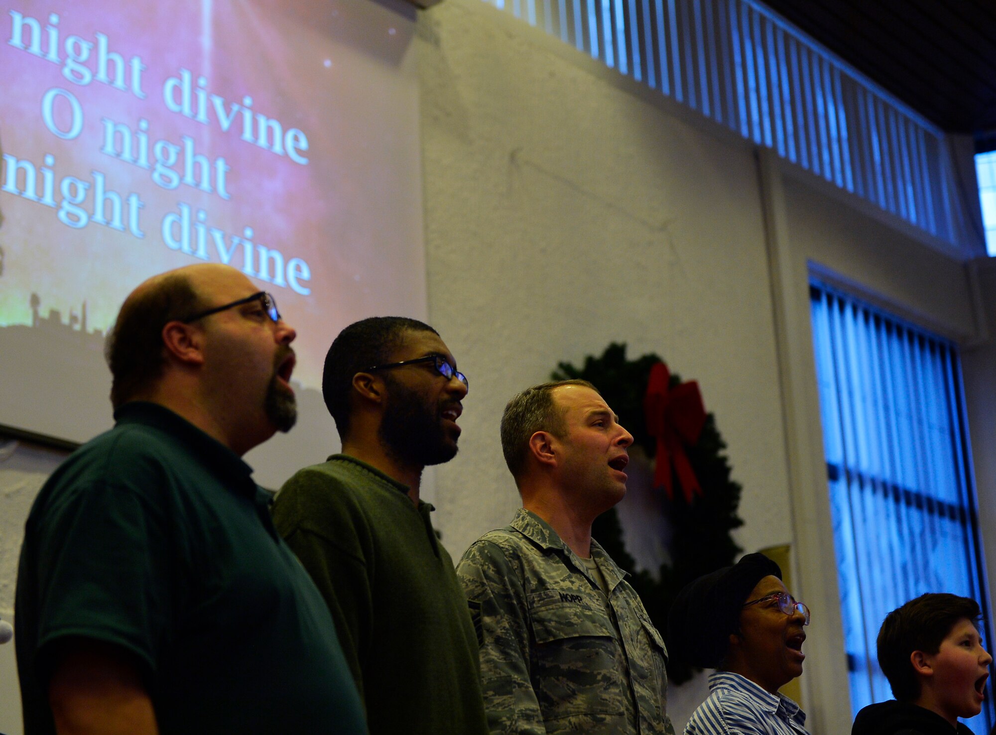 Choir members sing a traditional Christmas carol as part of an annual tree lighting ceremony in the Northside Chapel at Ramstein Air Base, Germany, Nov. 28, 2016. The musical program also included storytelling by the wing chaplain and a performance by the U.S. Air Forces in Europe band. (U.S. Air Force photo by Airman 1st Class Joshua Magbanua)