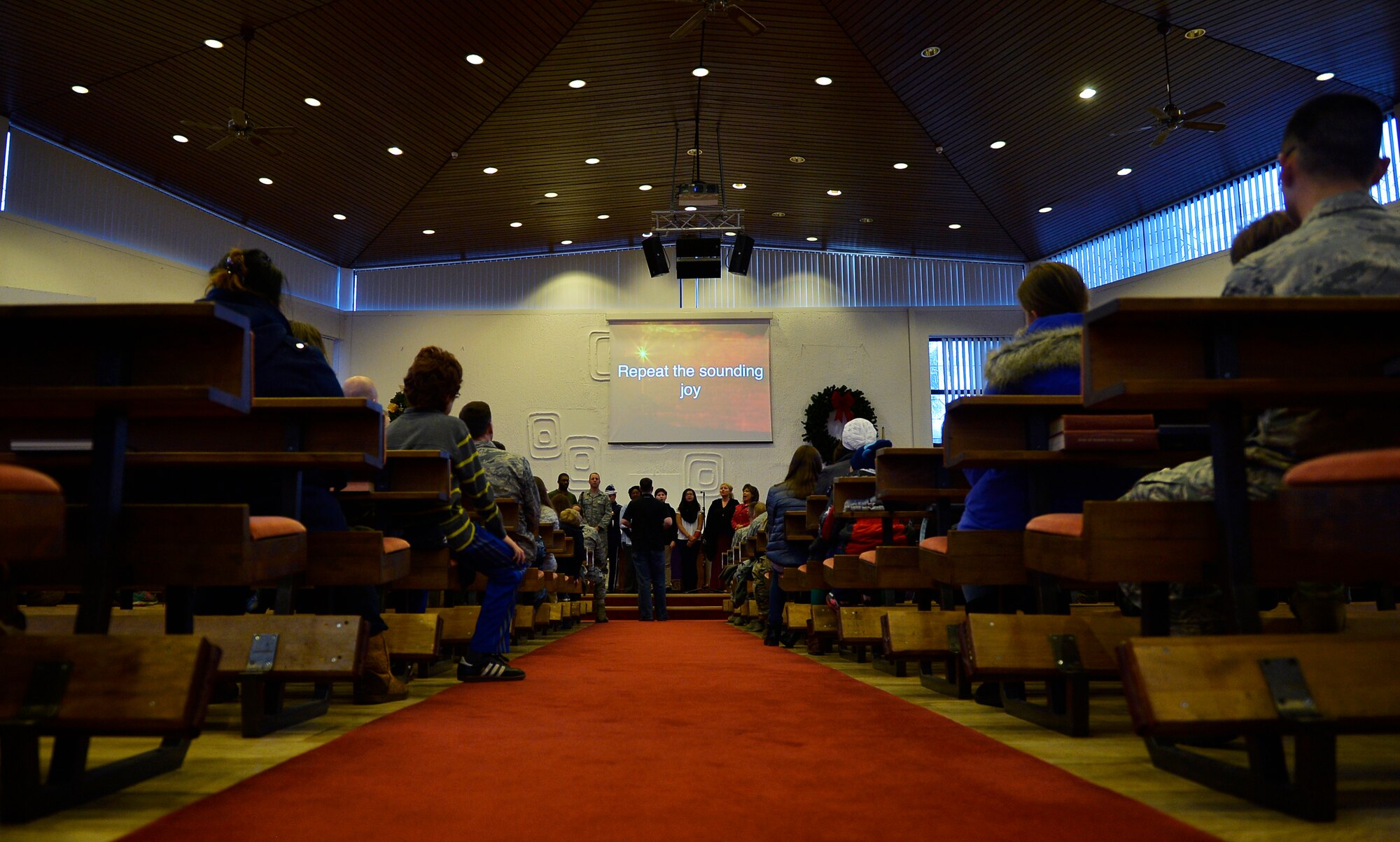 Kaiserslautern Military Community members  sing a traditional Christmas carol with a choir  in the Northside Chapel at Ramstein Air Base, Germany, Nov. 28, 2016. The performance was part of the base’s annual Christmas tree lighting ceremony, which not only highlighted the beginning of the holiday season, but also celebrated the base’s partnership with the local German community. (U.S. Air Force photo by Airman 1st Class Joshua Magbanua)
