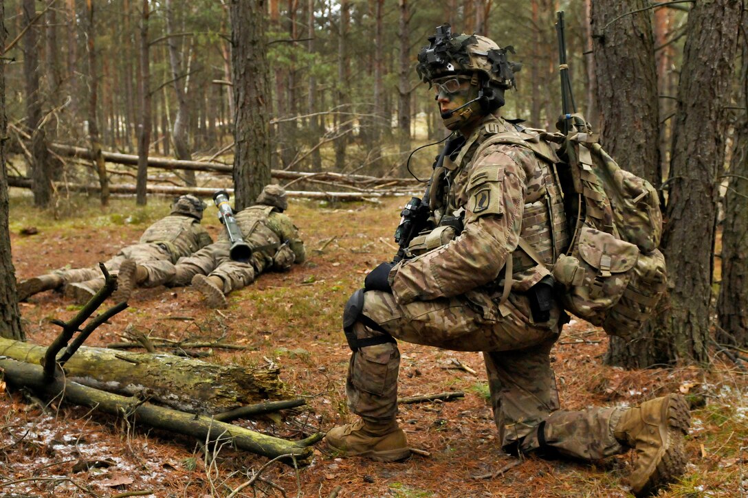 Army 1st Lt. Edward Cadwell, foreground, takes a knee after positioning his soldiers into tactical firing positions during live-fire training at Wedrzyn, Poland, Nov. 30, 2016. Cadwell is a platoon leader assigned to Company D, 2nd Battalion, 503rd Infantry Regiment, 173rd Airborne Brigade -- a unit regularly stationed in Germany. Army photo by Sgt. William A. Tanner
