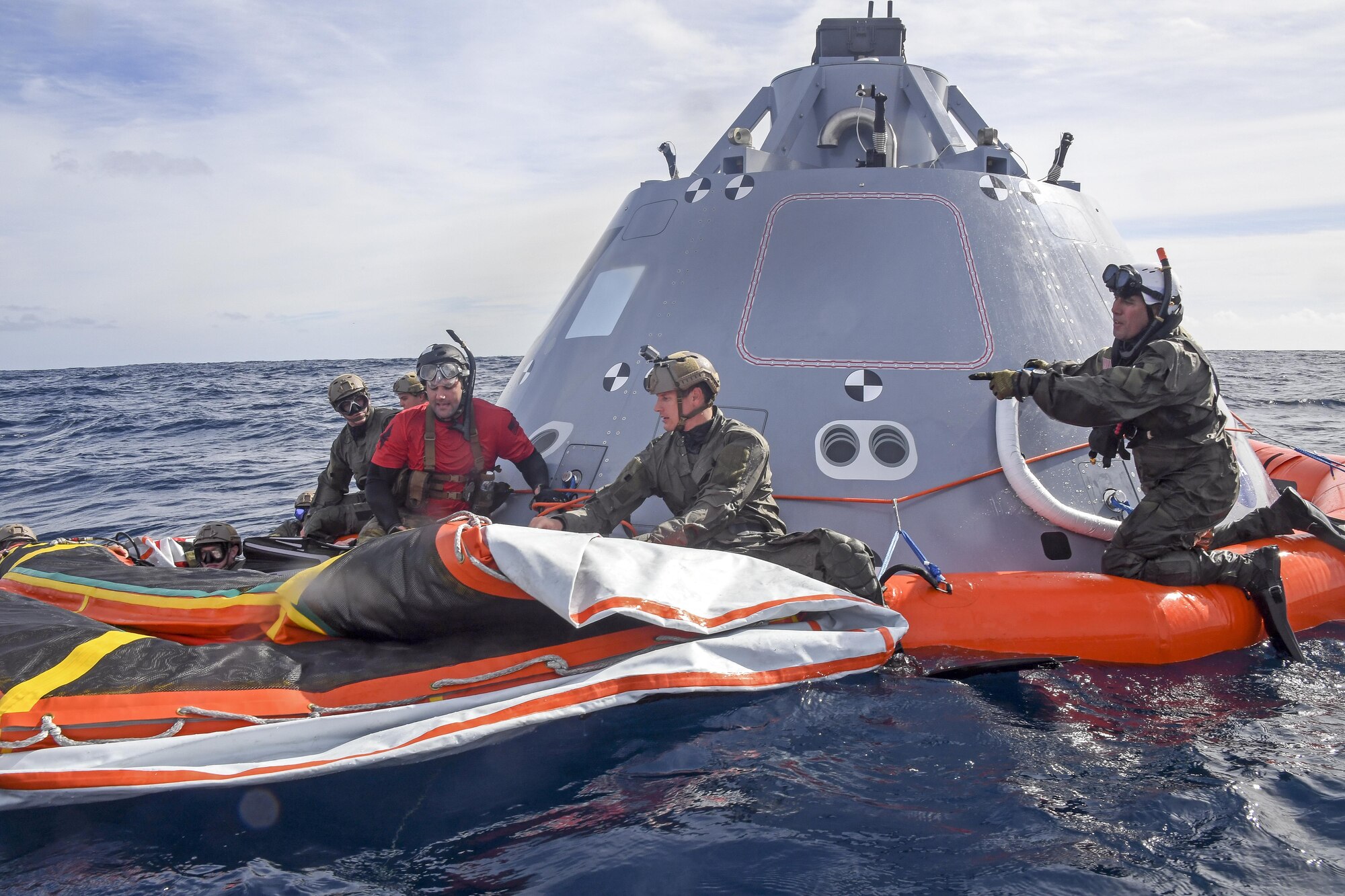 Master Sgt. Jermey Diola (right), a Para-Rescue Jumper assigned to Air Combat Command, instructs Navy Divers assigned to Explosive Ordnance Disposal Mobile Unit 3 and Mobile Dive and Salvage Company 3‐1 on the boilerplate-testing article, belonging to NASA’s Orion Program, in the Pacific Ocean, Oct. 31, 2016. USS San Diego (LPD 22) is currently conducting recovery and towing techniques utilizing NASA and Naval technology with the goal of reducing manning and increasing safety. (U.S. Navy Combat Camera photo by Petty Officer 3rd Class Alfred A. Coffield)