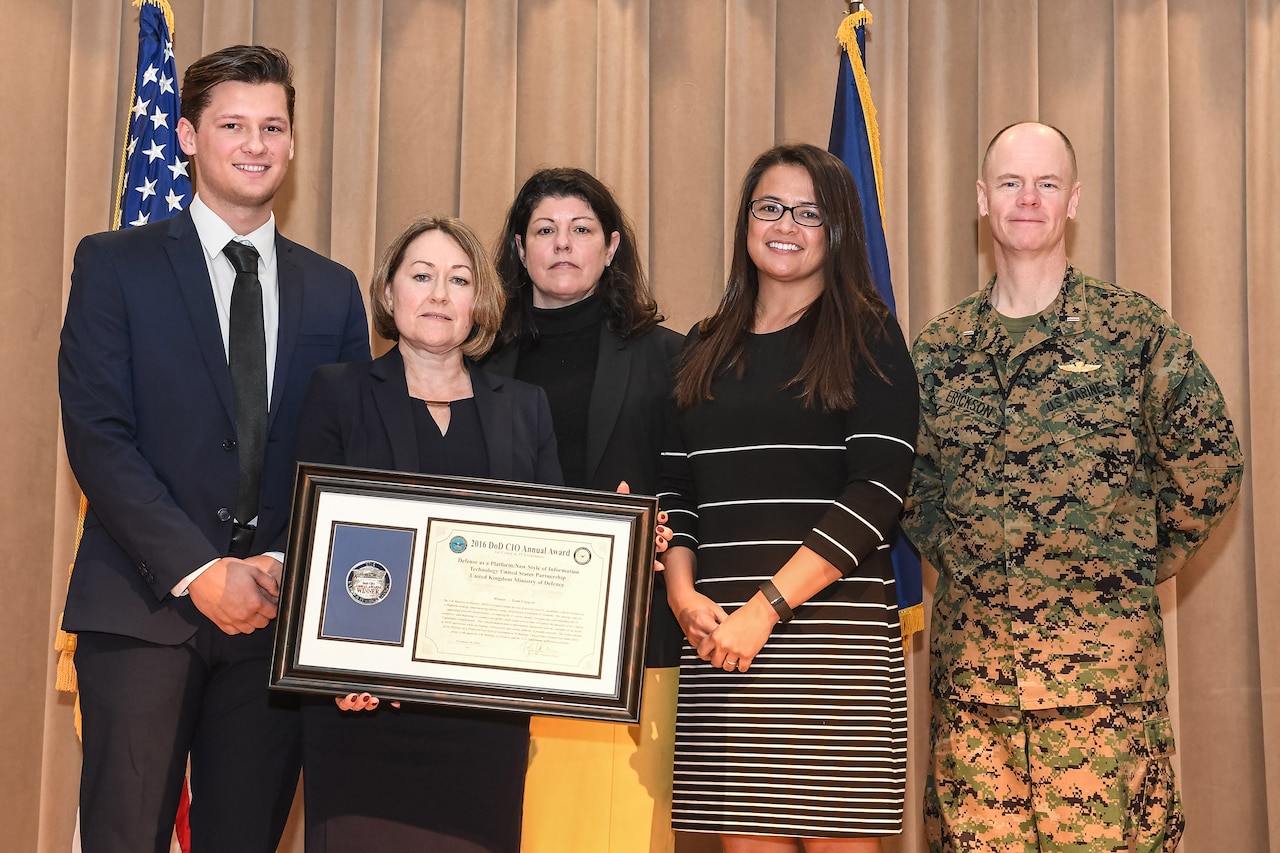 The Defense as a Platform/New Style Information Technology team, comprised of members from the U.S. Defense Department and the United Kingdom's Ministry of Defence, pose for a photo after receiving the first allied award at the 2016 DoD CIO annual award ceremony at the Pentagon conference center in Washington, D.C., Nov. 30, 2016. Army photo by Sgt. Alicia Brand