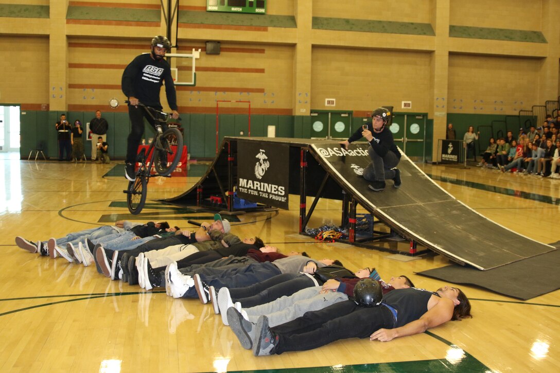 BMX rider Mykel Larrin performs a jump over Monrovia High School students at the school in Monrovia, Calif., during the Action Sports Association Entertainment high-school tour with the U.S. Marines from Recruiting Sub Station Pasadena, Nov. 29, 2016. The ASA High School Tour is a high-energy action sports circuit that visits cities across the United States supporting the Anti-Defamation League’s No Place for Hate campaign and the campaign for Tobacco-Free Kids.  ASA brings in five of the world’s top professional skateboarders, inline skaters and BMX riders from the X Games to perform on a state-of-the-art half-pipe, while an emcee delivers an educational message in a fun, positive and interactive fashion.  Students can win prizes, get autographs and participate in a variety of contests with our partners. (U.S. Marine Corps photo by Staff Sgt. Alicia R. Leaders/Released) 
