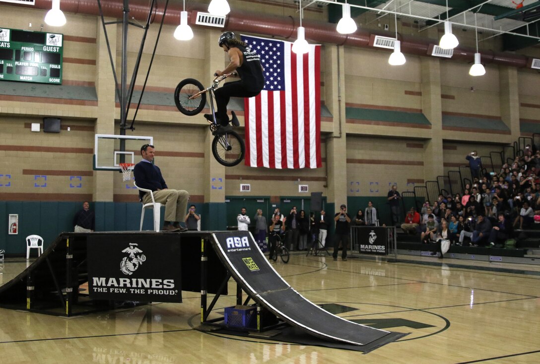 BMX rider Alex Landeros performs a jump over Monrovia High School Principal Kirk McGinnis at Monrovia High School in Monrovia, Calif., during the Action Sports Association Entertainment high-school tour with the U.S. Marines from Recruiting Sub Station Pasadena, Nov. 29, 2016. The ASA High School Tour is a high-energy action sports circuit that visits cities across the United States supporting the Anti-Defamation League’s No Place for Hate campaign and the campaign for Tobacco-Free Kids.  ASA brings in five of the world’s top professional skateboarders, inline skaters and BMX riders from the X Games to perform on a state-of-the-art half-pipe, while an emcee delivers an educational message in a fun, positive and interactive fashion.  Students can win prizes, get autographs and participate in a variety of contests with our partners. (U.S. Marine Corps photo by Staff Sgt. Alicia R. Leaders/Released) 