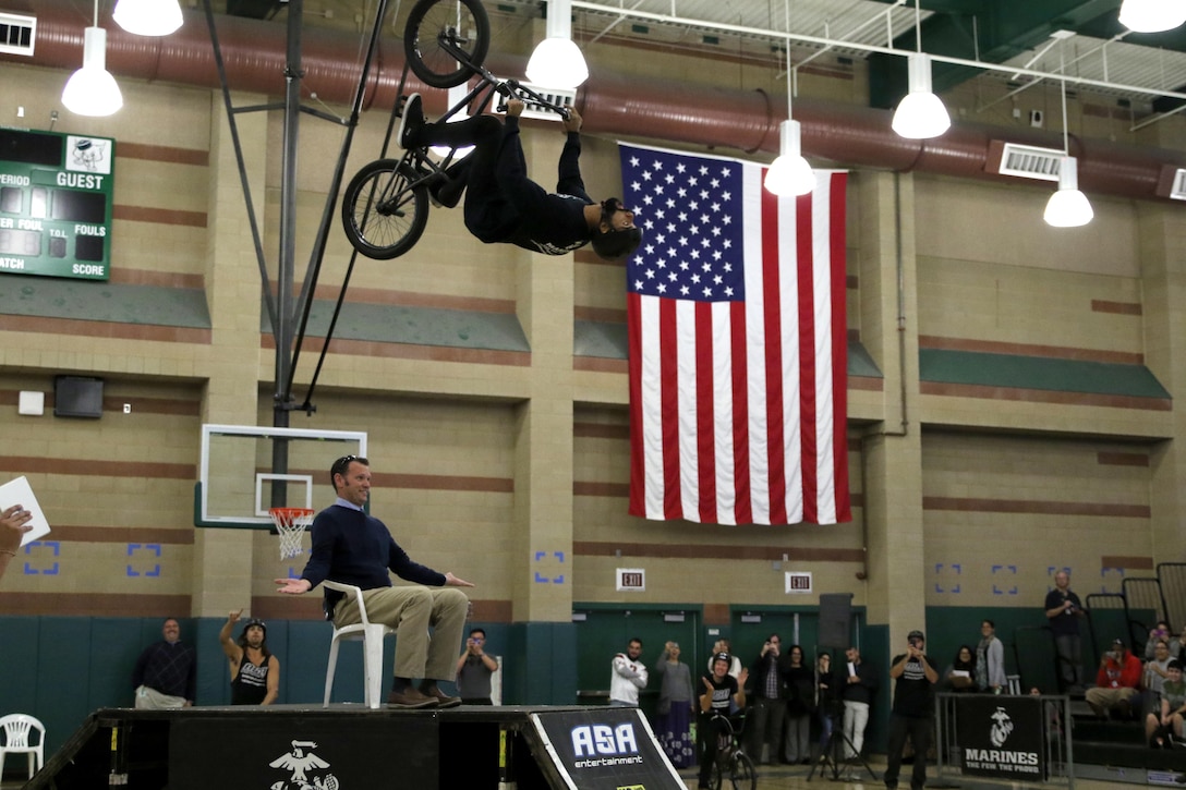 BMX rider Mykel Larrin performs a flip over Monrovia High School Principal Kirk McGinnis at Monrovia High School in Monrovia, Calif., during the Action Sports Association Entertainment high-school tour with the U.S. Marines from Recruiting Sub Station Pasadena, Nov. 29, 2016. The ASA High School Tour is a high-energy action sports circuit that visits cities across the United States supporting the Anti-Defamation League’s No Place for Hate campaign and the campaign for Tobacco-Free Kids.  ASA brings in five of the world’s top professional skateboarders, inline skaters and BMX riders from the X Games to perform on a state-of-the-art half-pipe, while an emcee delivers an educational message in a fun, positive and interactive fashion.  Students can win prizes, get autographs and participate in a variety of contests with our partners. (U.S. Marine Corps photo by Staff Sgt. Alicia R. Leaders/Released) 
