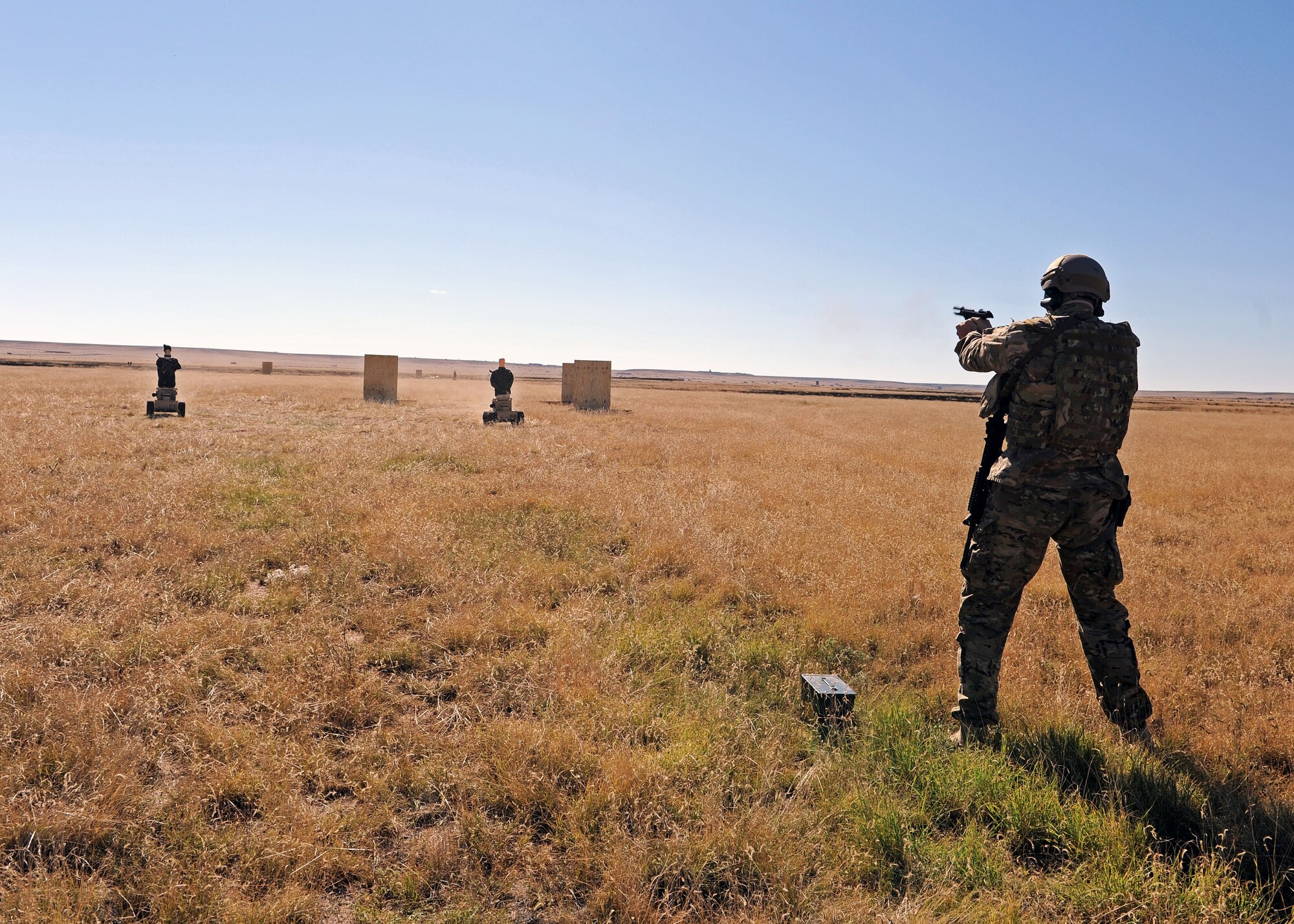 A member of the 27th Special Operations Civil Engineer Squadron Explosive Ordnance Disposal flight fires an M9 at two Robotic Human Type Targets as they approach during live fire training Nov. 8, 2016, at Melrose Air Force Range, N.M. RHTT targets are autonomous and smart in nature, allowing for the creation of infinite realistic scenarios which call for Air Commandos to employ elevated tactical thought processes, and execute appropriate courses of action with real-time urgency. (U.S. Air Force photo by Staff Sgt. Whitney Amstutz/Released)