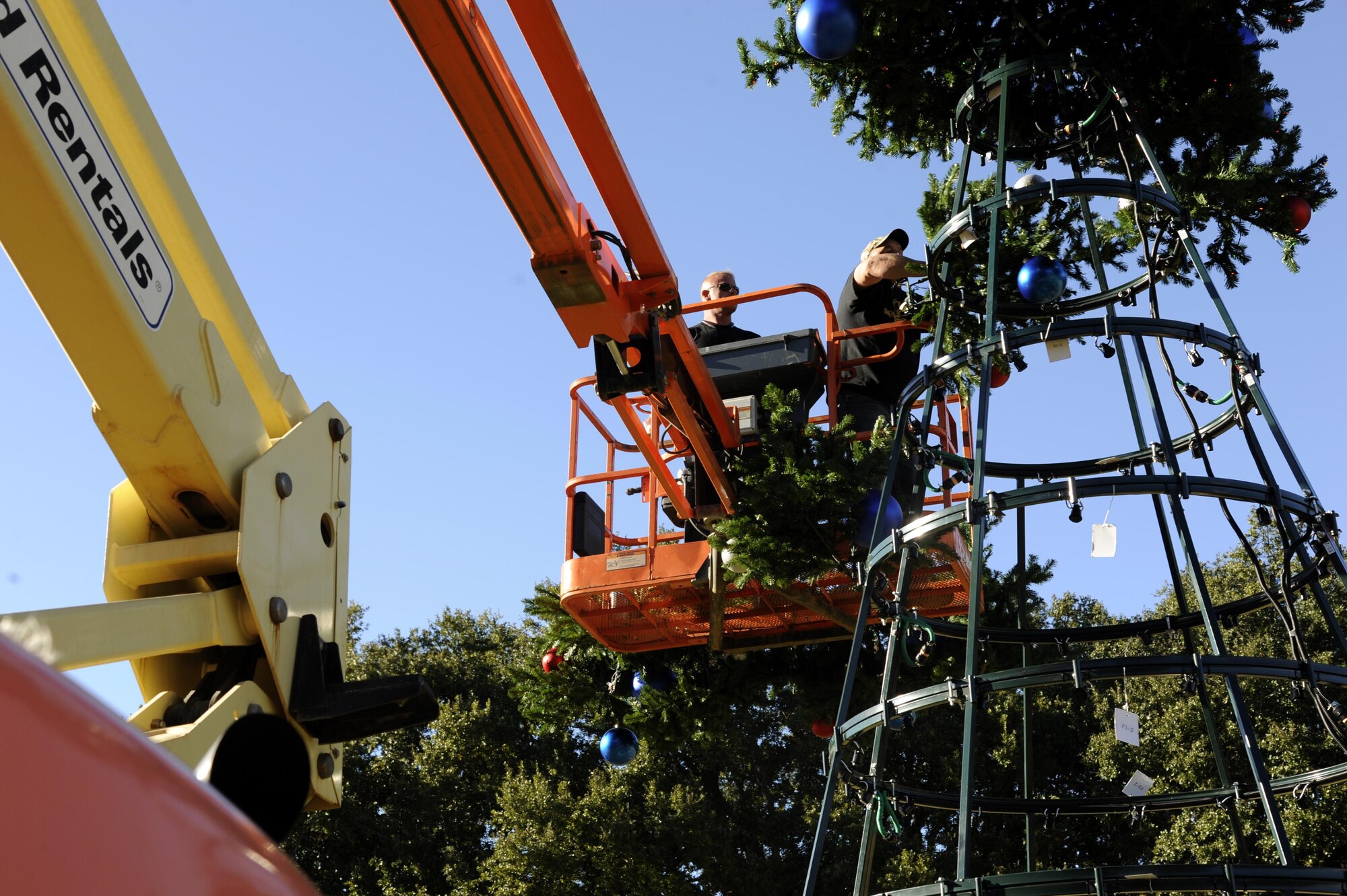 Jason Wynne, left, and Jason McMillan hang tree limbs on the Christmas tree in front of 2nd Bomb Wing headquarters at Barksdale Air Force Base, La., Nov. 30, 2016. The tree had more than 200 parts and took eight people to put it together. (U.S. Air Force photo/Staff. Sgt. Joseph A. Pagán Jr.)