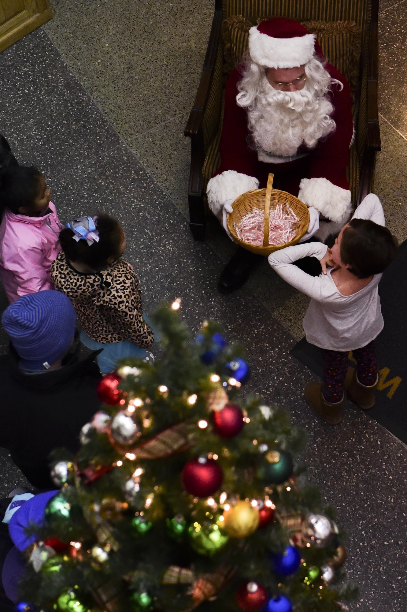 Santa Claus passes out candy to Team Buckley children during the annual Christmas tree lighting Nov. 30, 2016, at the 460th Space Wing Headquarters building on Buckley Air Force Base, Colo. Members of Team Buckley gathered together to celebrate the start of the holiday season. (U.S. Air Force photo by Airman 1st Class Gabrielle Spradling/Released)