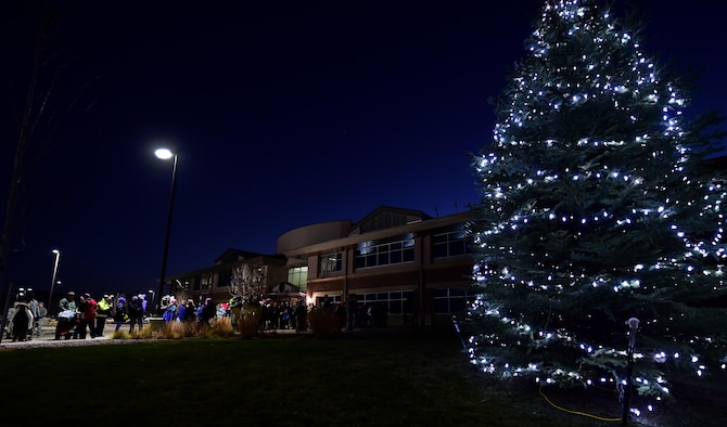 Members of Team Buckley gather at the 460th Space Wing Headquarters building for the annual Christmas tree lighting ceremony Nov. 30, 2016, on Buckley Air Force Base, Colo.  The tree lighting ceremony included refreshments, carolers and even a visit from Santa Claus. (U.S. Air Force photo by Airman Holden S. Faul/ Released)