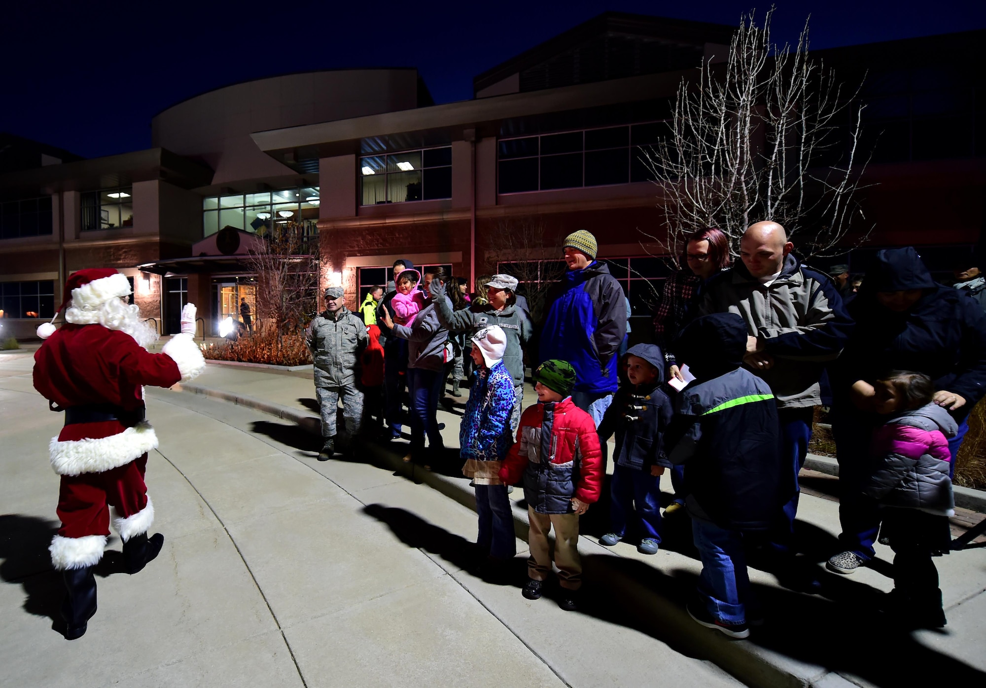 Families from Team Buckley welcome Santa during the annual Christmas tree lighting Nov. 30, 2016, at the 460TH Space Wing Headquarters building on Buckley Air Force Base, Colo. After meeting with families outside, Santa greeted more children inside the headquarters building to pass out candy. (U.S. Air Force photo by Airman Holden S. Faul/ Released)