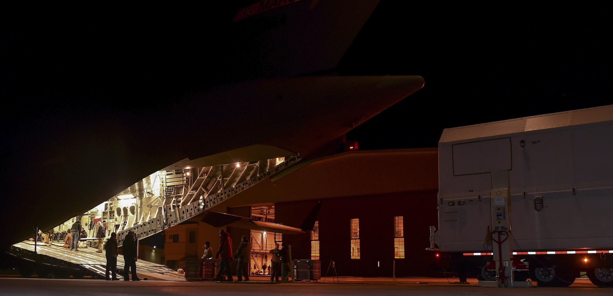 Members from Lockheed Martin prepare the loading ramp of a C-17 Globemaster III Nov. 30, 2016, at Buckley Air Force Base, Colo. Members from Lockheed Martin worked with an aircrew from the 729th Airlift Squadron to load a GPS non-flight satellite testbed prior to flying to Cape Canaveral, Florida. The GPS non-flight satellite testbed is a pathfinder vehicle used by the Space and Missile Systems Center to ensure future GPS III vehicles are adequately tested. (U.S. Air Force photo by Airman Holden S. Faul/ Released) 