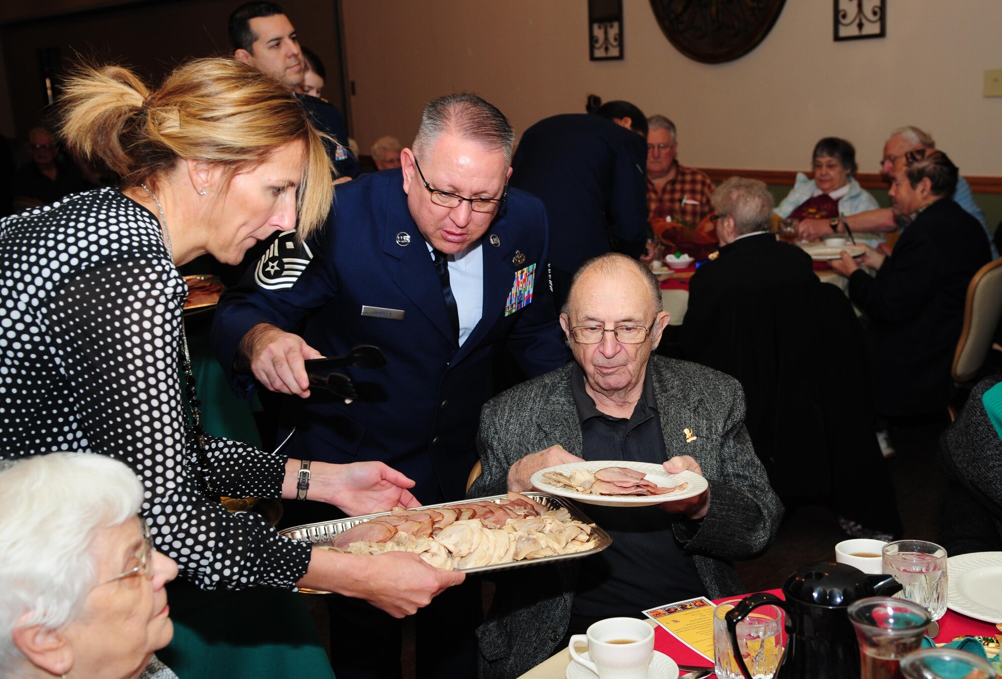 Master Sgt. Robert Dooley, 5th Logistics Readiness Squadron first sergeant, serves food during the annual Day of Love at Minot Air Force Base, N.D., Nov. 24, 2016. Minot has held the event annually since 1969. (U.S. Air Force photo/Airman 1st Class Christian Sullivan)