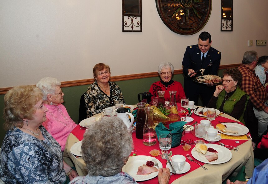 Major Carlos DeDios, 5th Bomb Wing deputy judge advocate, serves food during the annual Day of Love at Minot Air Force Base, Nov. 24, 2016. During the event, Minot senior citizens are invited on base for a Thanksgiving meal served by military members. (U.S. Air Force photo/Airman 1st Class Christian Sullivan)