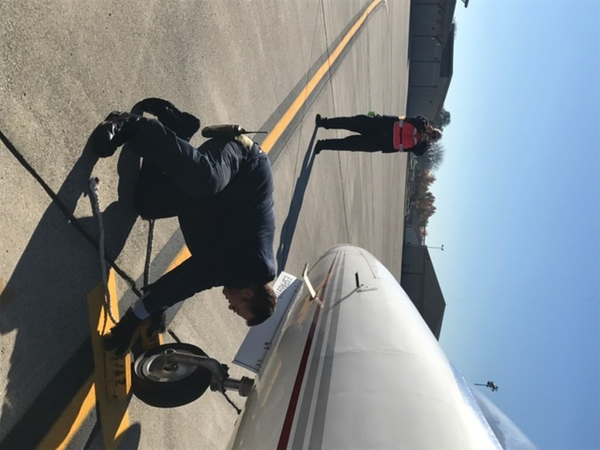 Aircraft Servicers Mark Foster and Larry Weis assist in the recovery of a Medivac aircraft.  (U.S. Air Force photo/Stacey Geiger)