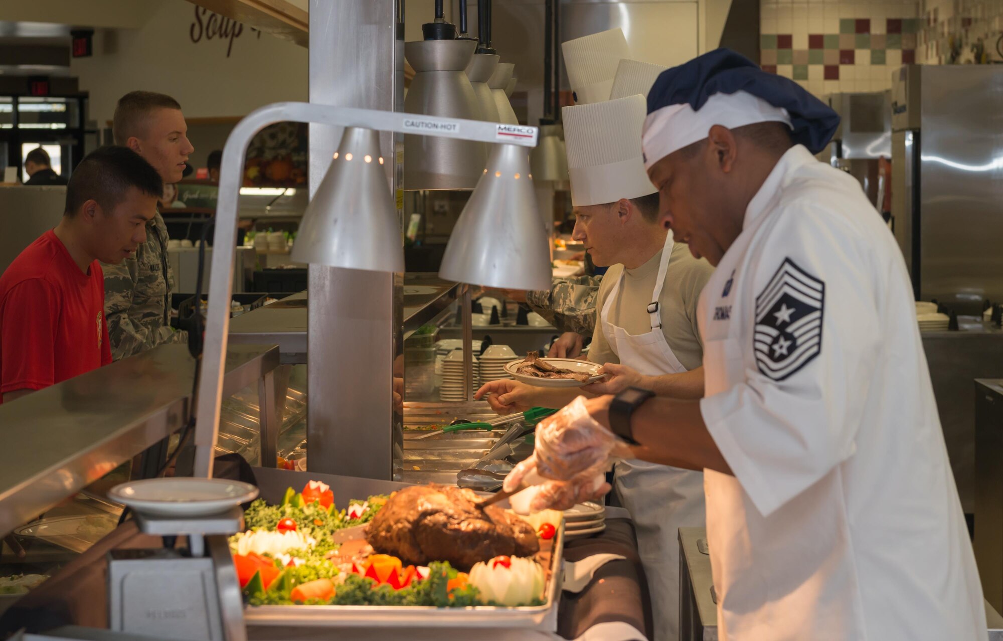 Col. Todd Weyerstrass, 2nd Air Force vice commander, and Chief Master Sgt. Farrell Thomas, 2nd AF command chief, serve a Thanksgiving meal to service members at the Azalea Dining Facility, Nov. 24, 2016, on Keesler Air Force Base, Miss. It is tradition at Keesler for commanders, first sergeants and superintendents to serve a Thanksgiving meal at the dining facility to technical training and permanent party Airmen who are not able to go home for the holiday weekend. (U.S. Air Force photo by Andre’ Askew)