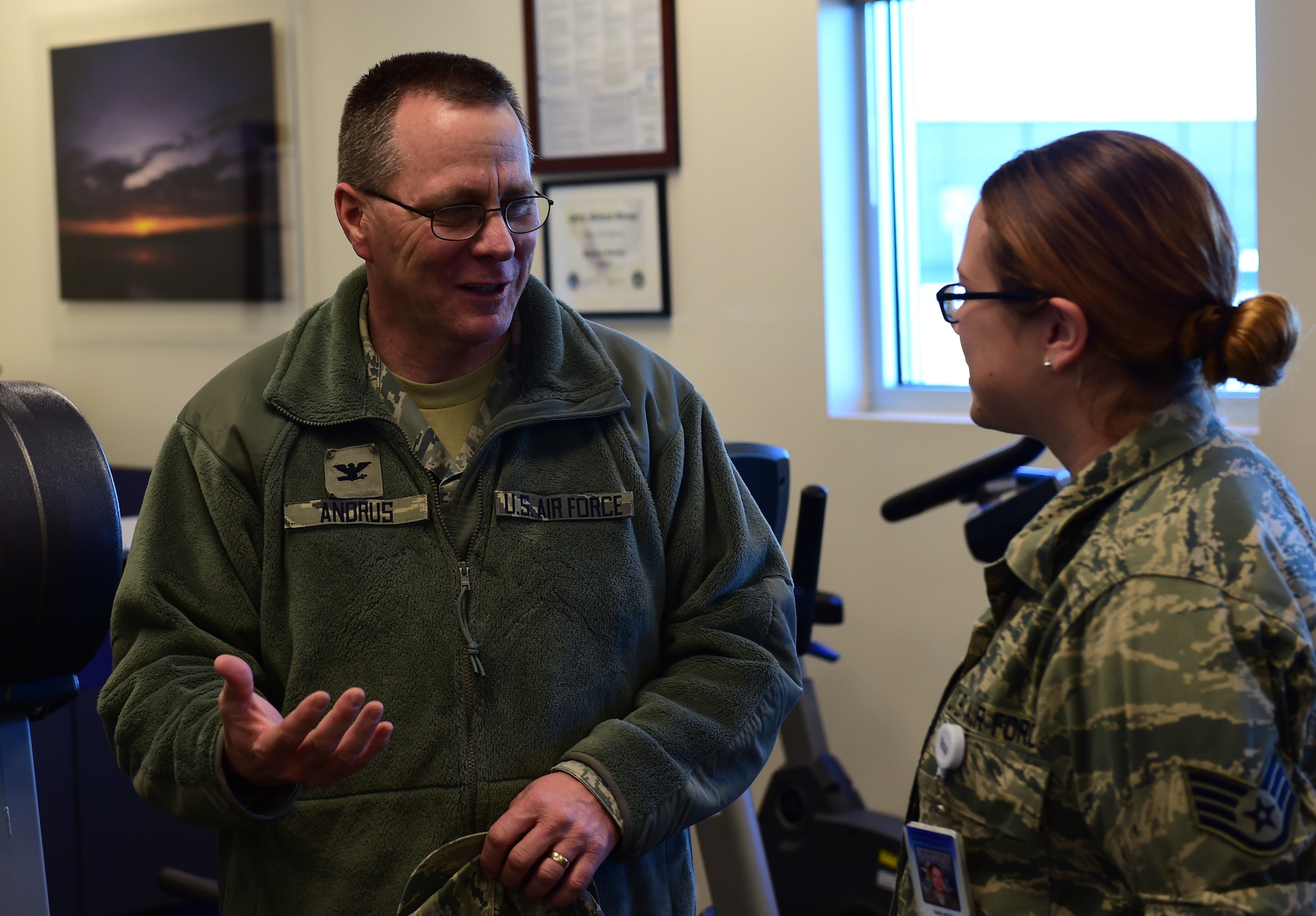 Col. John R. Andrus, Air Force Space Command Surgeon General, discusses current treatment methods with Staff Sgt. Tara L. Moss, 460th Medical Group physical therapy technician Nov. 30, 2016, at the Health and Wellness Center on Buckley Air Force Base, Colo. Moss received a coin from the Surgeon General for her outstanding work with patients undergoing rehabilitation. (U.S. Air Force photo by Airman Jacob Deatherage/Released)