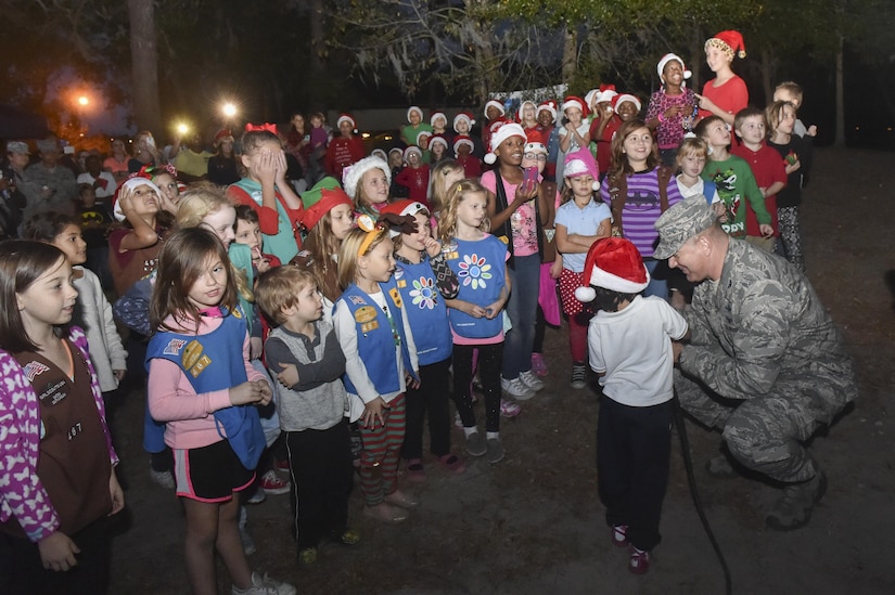 U.S. Air Force Col. Robert Lyman, Joint Base Charleston commander, with the assistance of children from here, prepare to plug in the lights for the holiday tree on the Joint Base Charleston - Air Base Nov. 30, 2016. Families and children gathered for caroling, hot chocolate, photos with Santa and the annual lighting of the holiday tree on base.