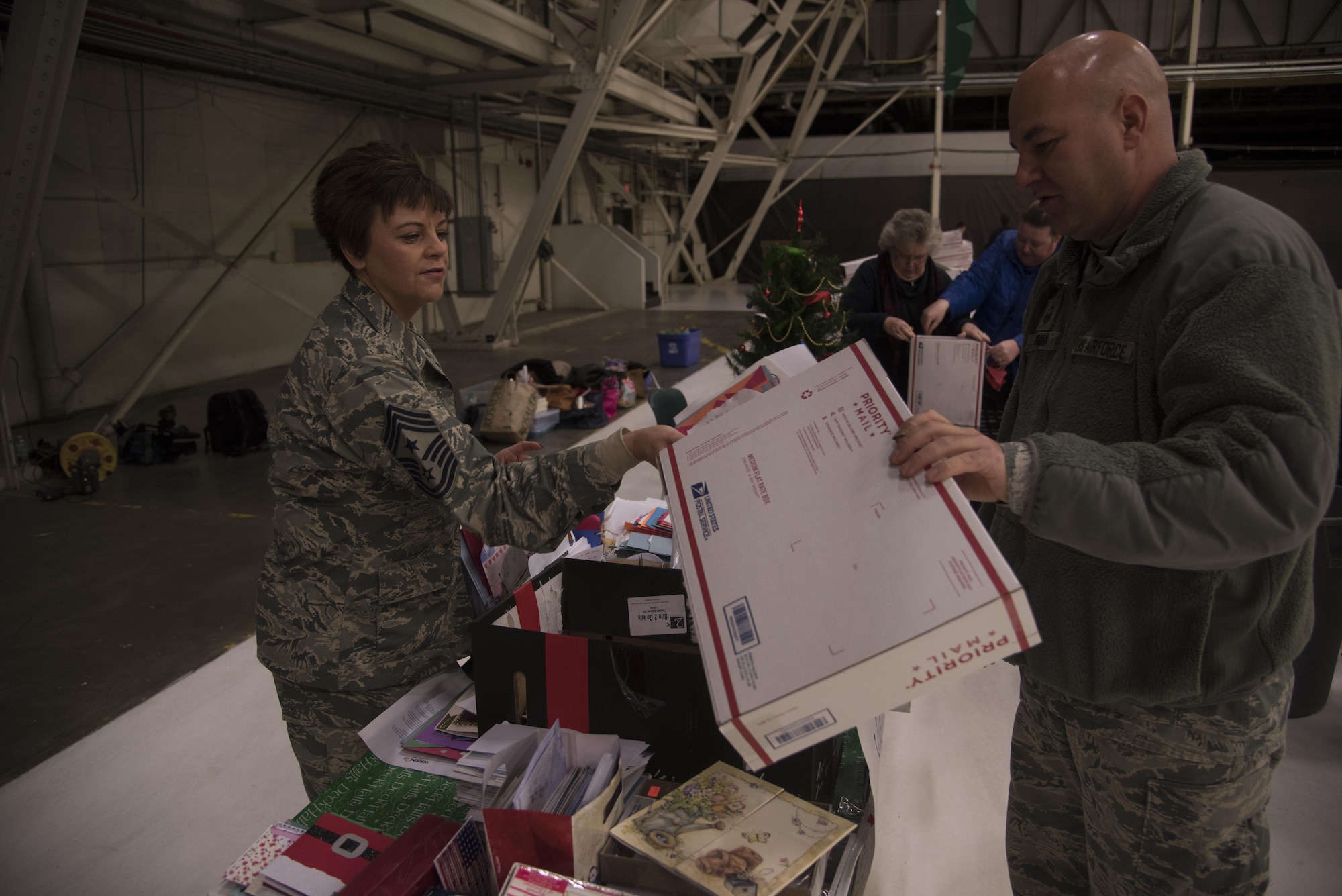 Chief Master Sgt. Shannon Rix, 92nd Air Refueling Wing command chief, and Master Sgt. Nicholas Ehman, 92nd Maintenance Squadron accessories flight assistant flight chief, pack letters into a shipping box Dec. 1, 2016 at Fairchild Air Force Base. Letters and other items were packed into boxes as part of KREM 2 News Treats 2 Troops program. Treats 2 Troops is a program that allows people to support deployed military members. (U.S. Air Force photo/Senior Airman Nick J. Daniello)