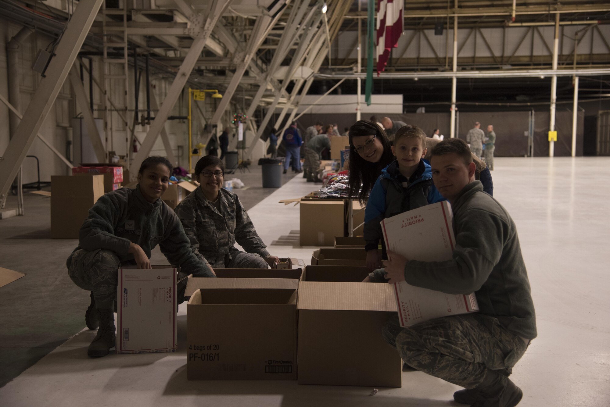 Team Fairchild volunteers pack items into care packages as part of KREM 2 News Treats 2 Troops program Dec. 1, 2016 at Fairchild Air Force Base. Volunteers packaged more than 400 boxes that will be delivered to deployed military members. The boxes are filled with various items, such as hot sauce, wet wipes, beef jerky, toothbrushes, and magazines. (U.S. Air Force photo/Senior Airman Nick J. Daniello)
