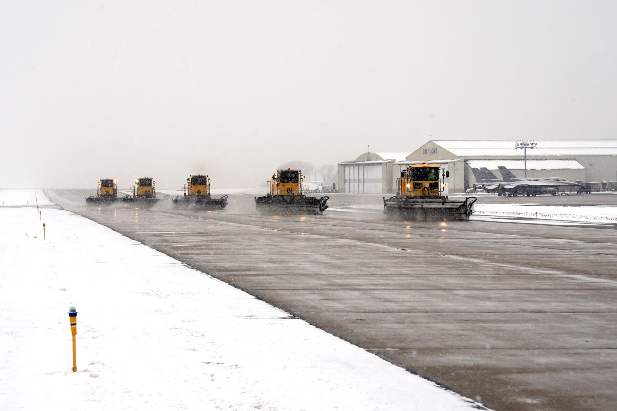 High-capacity sweeper vehicles clear the Hill Air Force Base taxiway of snow, Dec. 1, 2016. These trucks and other snow removal vehicles are kept in top shape to ensure the airfield is operational all winter long, during any weather conditions. (U.S. Air Force photos by Todd Cromar)