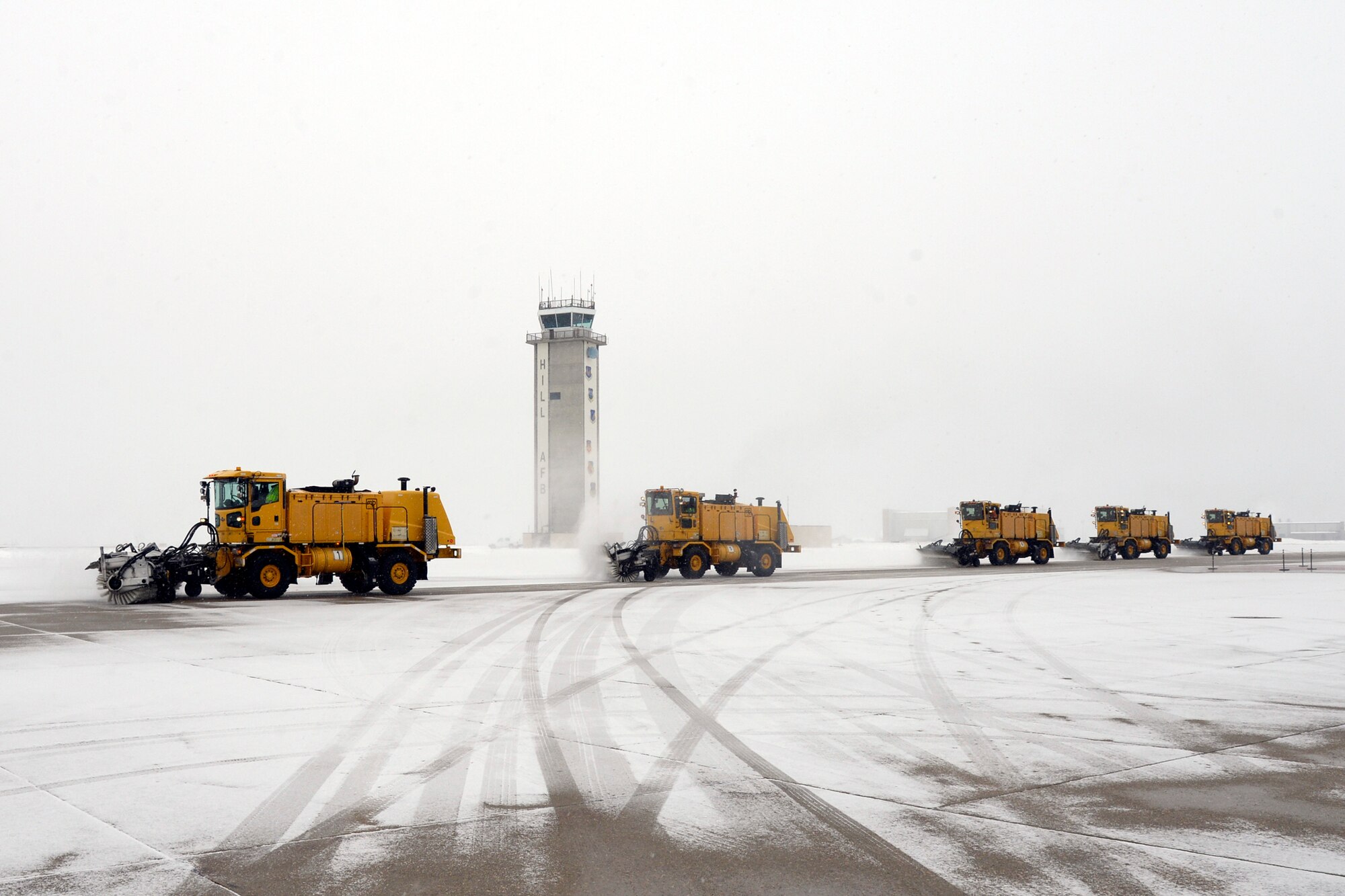 High-capacity sweeper vehicles clear the Hill Air Force Base taxiway of snow, Dec. 1, 2016. During the winter season from Nov. 1 through April 1, the snow removal team has 70 employees who work 24/7, operating 65 pieces of snow-removal equipment to remove 65-70 inches of snow each year. (U.S. Air Force photos by Todd Cromar)