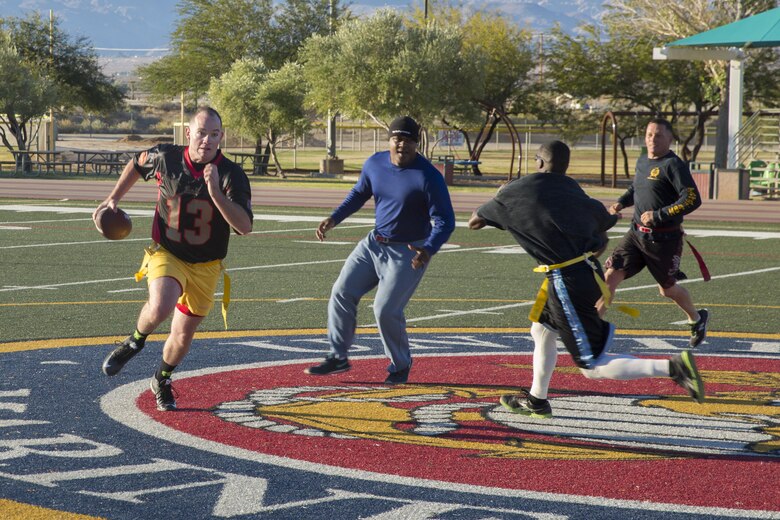 1st Lt. Andrew de Lannoy, combat engineer officer, Marine Wing Support Squadron 374, rushes the ball pass the staff noncommissioned officers’ defensive line during the MWSS-374 Turkey Bowl at Felix Field aboard the Marine Corps Air Ground Combat Center, Twentynine Palms, Calif., Nov. 22, 2016. MWSS-374 held the Turkey Bowl to build camaraderie within the senior leadership. (Official Marine Corps photo by Lance Cpl. Dave Flores/Released)