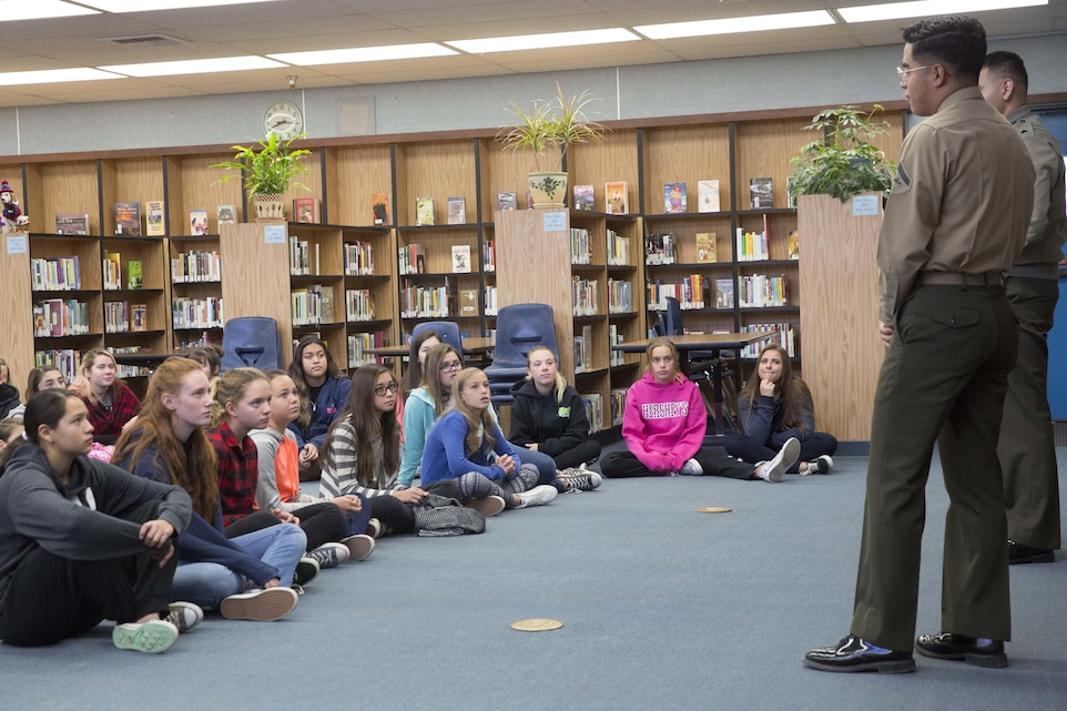 Cpl. Julio McGraw and Lance Cpl. Dave Flores, combat correspondents, Headquarters Battalion, answer students’ questions during a visit to La Contenta Middle School in Yucca Valley, Calif., Nov. 30, 2016. Don Henry, a teacher at the middle school, coordinates the event annually in an effort to teach his students about the military while giving them a chance to show their appreciation in the form of letters. (Official Marine Corps photo by Cpl. Medina Ayala-Lo/Released)