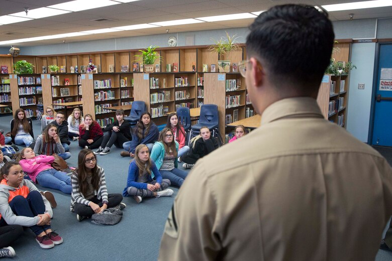 Lance Cpl. Dave Flores, combat correspondent, Headquarters Battalion, answers students’ questions during a visit to La Contenta Middle School in Yucca Valley, Calif., Nov. 30, 2016. Don Henry, a teacher at the middle school, coordinates the event annually in an effort to teach his students about the military while giving them a chance to show their appreciation in the form of letters. (Official Marine Corps photo by Cpl. Medina Ayala-Lo/Released)