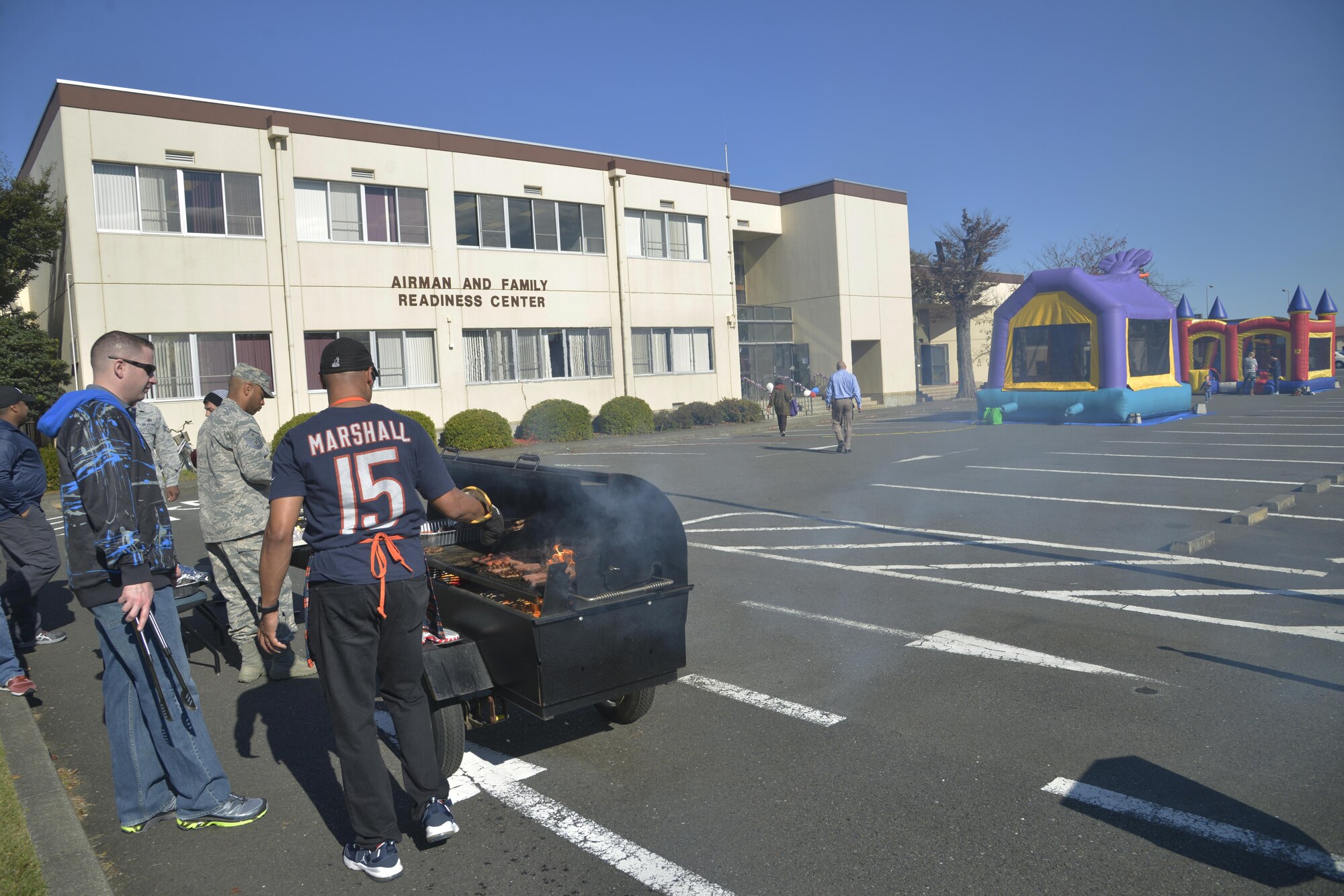 Yokota members cook hot dogs and hamburgers on a grill outside of the Airman & Family Readiness Center at Yokota Air Base, Japan, Nov. 29, 2016. The AFRC provides Airmen and families support and services, contributes to mission readiness, resiliency, and the well-being of the Air Force community. (U.S. Air Force photo by Staff Sgt. David Owsianka/Released)