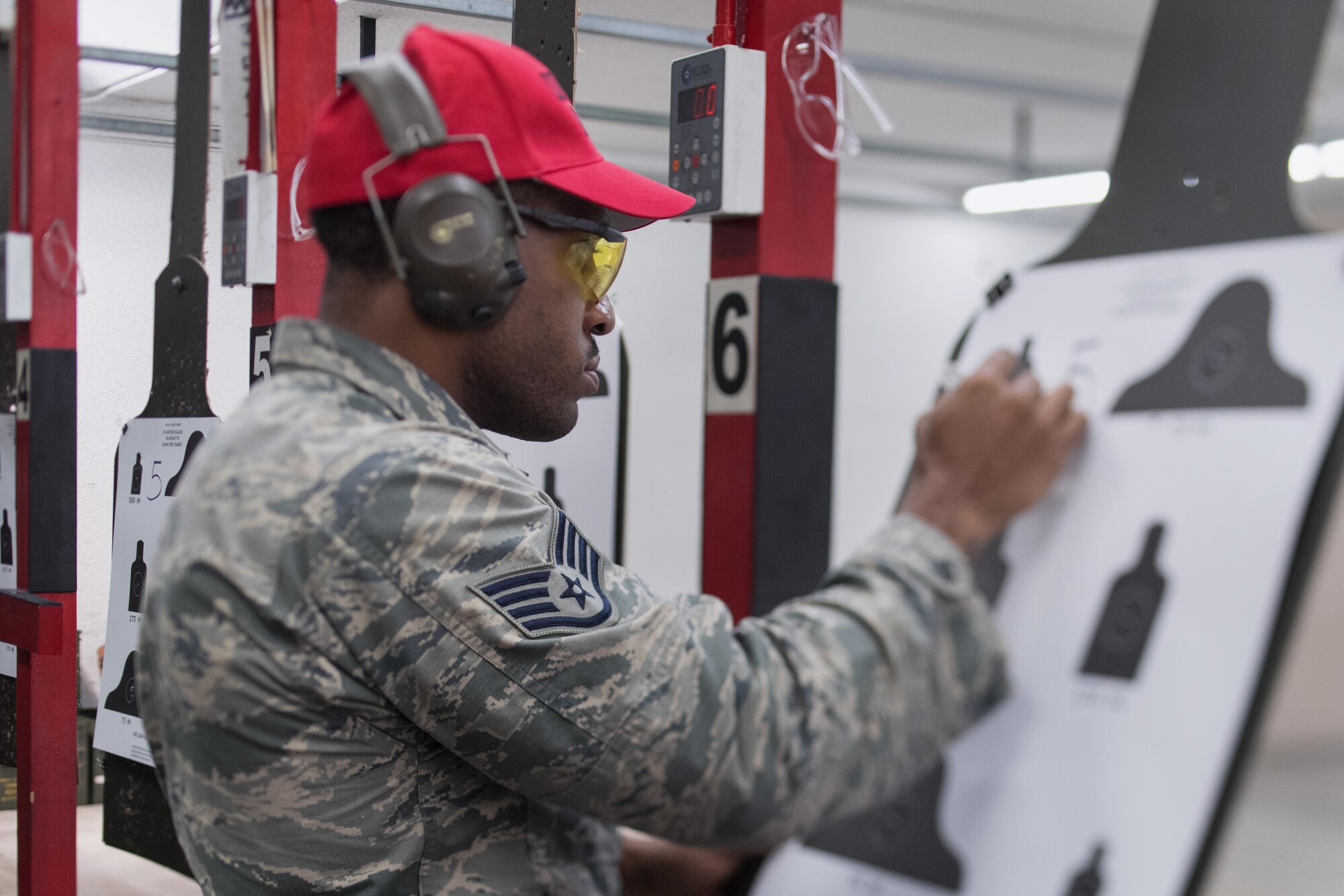 Senior Airman Dominique Adams, 374th Security Forces Squadron combat arms instructor, scores a target during a during a weapons qualification test at Yokota Air Base, Japan, Dec. 1. 2016. Yokota’s Combat Arms Maintenance and Training course trains between 2,500 - 3,000 students each year. (U.S. Air Force photo by Senior Airman Delano Scott/Released)