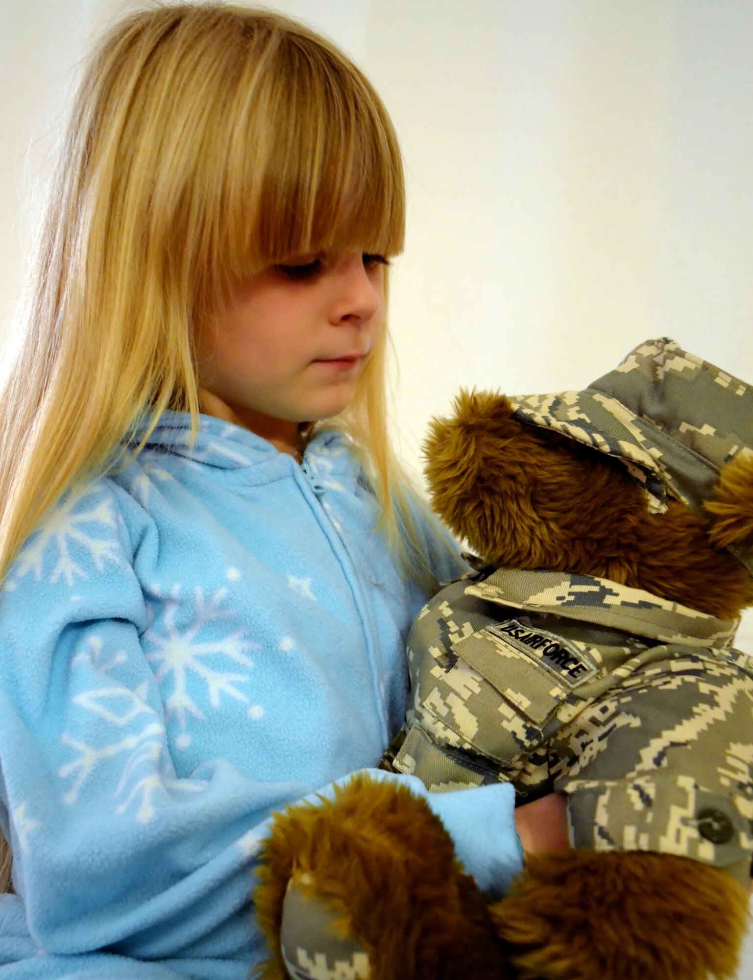 The daughter of a 111th Attack Wing member cuddles with a teddy bear, given to her by the Horsham Air Guard Station Airman & Family Readiness Center, at her home in Philadelphia, Pa., Nov. 30, 2016. The National Guard has programs in place to help ease stress on the children of deployed military members. (U.S. Air National Guard photo by Tech. Sgt. Andria Allmond)