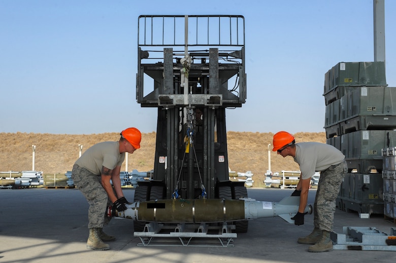 U.S. Air Force Senior Airman Ross and Staff Sgt. Benjamin, both 447th Expeditionary Aircraft Maintenance Squadron munitions systems journeymen, lower a GBU-54 Laser Joint Direct Attack Munition bomb onto a storage pallet Oct. 29, 2016, at Incirlik Air Base, Turkey. The bombs will be taken to another location to be tested for serviceability. (U.S. Air Force photo by Airman 1st Class Devin M. Rumbaugh) (Portions of this image are blocked for security concerns)