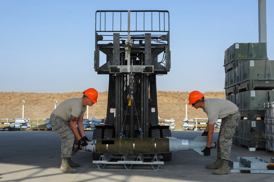 U.S. Air Force Senior Airman Ross and Staff Sgt. Benjamin, both 447th Expeditionary Aircraft Maintenance Squadron munitions systems journeymen, lower a GBU-54 Laser Joint Direct Attack Munition bomb onto a storage pallet Oct. 29, 2016, at Incirlik Air Base, Turkey. The bombs will be taken to another location to be tested for serviceability. (U.S. Air Force photo by Airman 1st Class Devin M. Rumbaugh) (Portions of this image are blocked for security concerns)