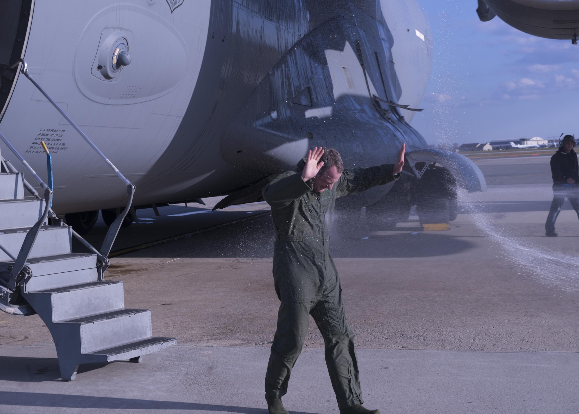 Marsha Graham sprays her husband Col. Robert P. Graham, 512th Airlift Wing vice commander, after he completed his final military flight, Dec. 1, 2016, Dover Air Force Base, Del. Graham has served in the Air Force since 1986 and logged more than 4,500 flight hours including 300 combat support hours. (U.S. Air Force Photo/ Tech. Sgt. Nathan Rivard)