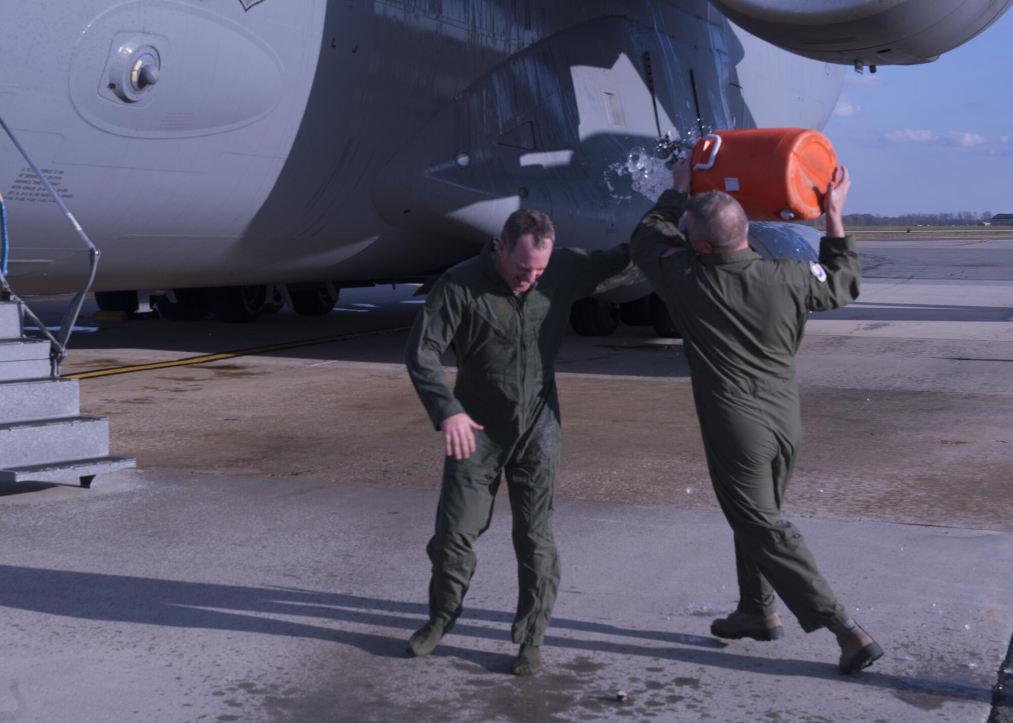 Col. Scott. D. Durham, 512th Airlift Wing commander, chases Col. Robert P. Graham, 512th Airlift Wing vice commander, with a water cooler after Graham completed his final military flight, Dec. 1, 2016, Dover Air Force Base, Del. Graham has served in the Air Force since 1986 and logged more than 4,500 flight hours including 300 combat support hours. (U.S. Air Force Photo/ Tech. Sgt. Nathan Rivard)