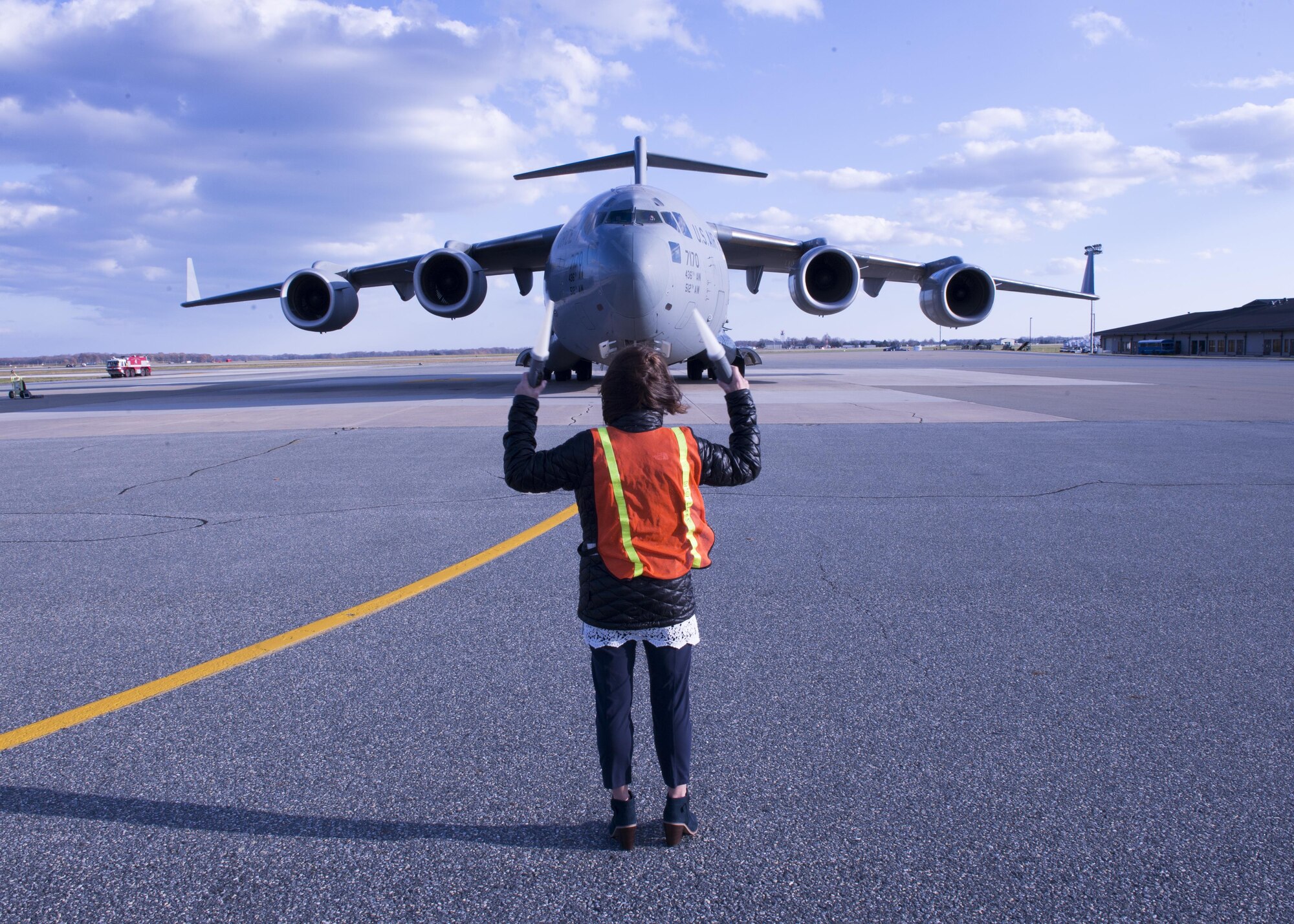 Marsha Graham marshals her husband Col. Robert P. Graham, 512th Airlift Wing vice commander, on the taxiway in a C-17 Globemaster III during his final military flight, Dec.1, 2016, Dover Air Force Base, Del. Graham has served in the Air Force since 1986 and logged more than 4,500 flight hours including 300 combat support hours. (U.S. Air Force Photo/ Tech. Sgt. Nathan Rivard)