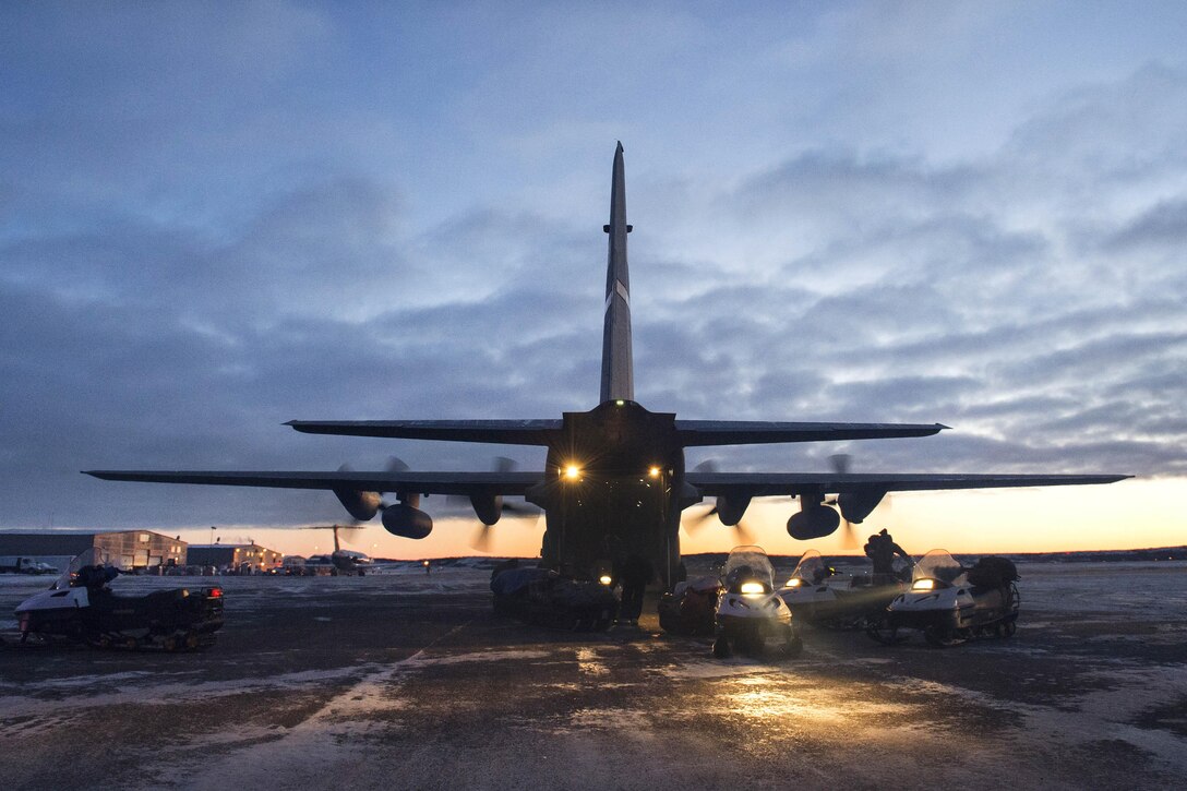 Marines offload snow machines and gear from a HC-130 Hercules aircraft during Toys for Tots at Kotzebue, Alaska, Nov. 28, 2016. Air Force photo by Alejandro Pena