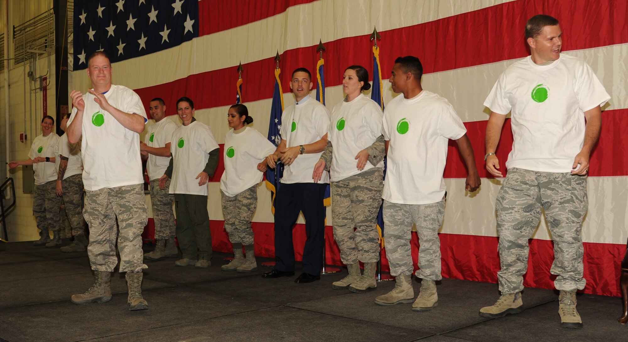PETERSON AIR FORCE BASE, Colo. – Col. James DeVere, front, 302nd Airlift Wing commander, dons a Green Dot t-shirt along with other 302nd AW members during the November Unit Training Assembly wing commander’s call, Nov. 5, 2016, here. DeVere emphasized the program’s importance and explained every Airman is a vital part to its success.  Green Dot prepares organizations to implement a strategy of violence prevention that reduces power-based interpersonal violence, which includes not only sexual violence, but also domestic violence, dating violence, stalking, child abuse, elder abuse, and bullying. The U.S. Air Force implemented the Green Dot program across the service in January, 2016.  (U.S. Air Force photo/Staff Sgt. Amber Sorsek)