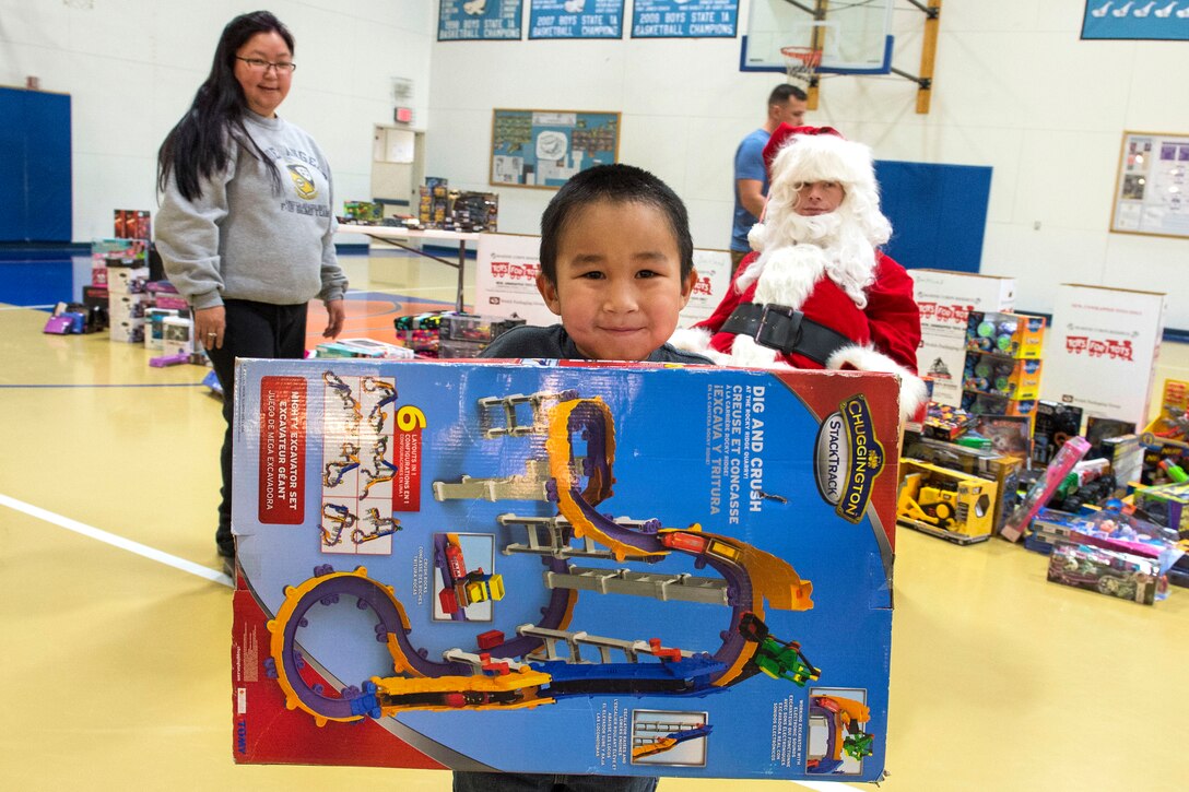 A child displays a gift given to him Santa Claus during Toys for Tots at Nunachiam Sissauni School in Buckland, Alaska, Nov. 29, 2016. Santa was assisted by by Marine Corps 1st Sgt. Joshua Guffey, the inspector-instructor first sergeant assigned to Detachment Delta, 4th Law Enforcement Battalion. Air Force photo by Alejandro Pena