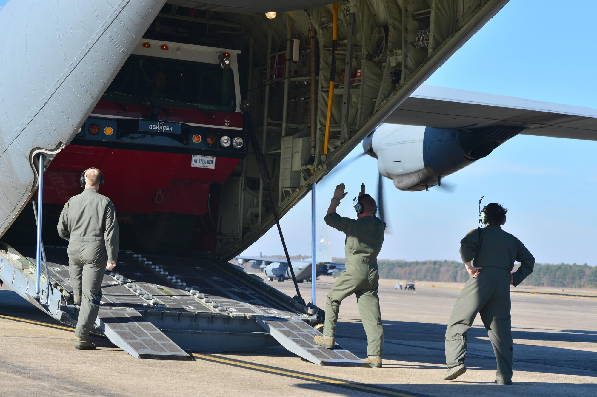 Loadmasters from the 913th Airlift Group guide a fire truck onto a C-130J as part of the Turkey Shoot competition Nov. 17, 2016, at Little Rock Air Force Base, Ark.at Little Rock Air Force Base, Ark. The Turkey Shoot is a multiple event test which evaluates all aspects of combat airlift such as threat mitigation, container delivery system airdrops, assault landings and loading and offloading vehicles. (U.S. Air Force photo by Airman 1st Class Grace Nichols)