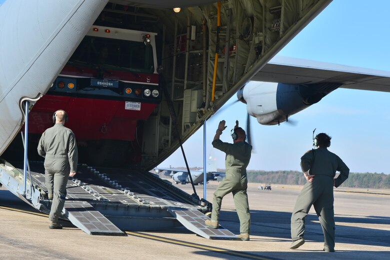 Loadmasters from the 913th Airlift Group guide a fire truck onto a C-130J as part of the Turkey Shoot competition Nov. 17, 2016, at Little Rock Air Force Base, Ark.at Little Rock Air Force Base, Ark. The Turkey Shoot is a multiple event test which evaluates all aspects of combat airlift such as threat mitigation, container delivery system airdrops, assault landings and loading and offloading vehicles. (U.S. Air Force photo by Airman 1st Class Grace Nichols)